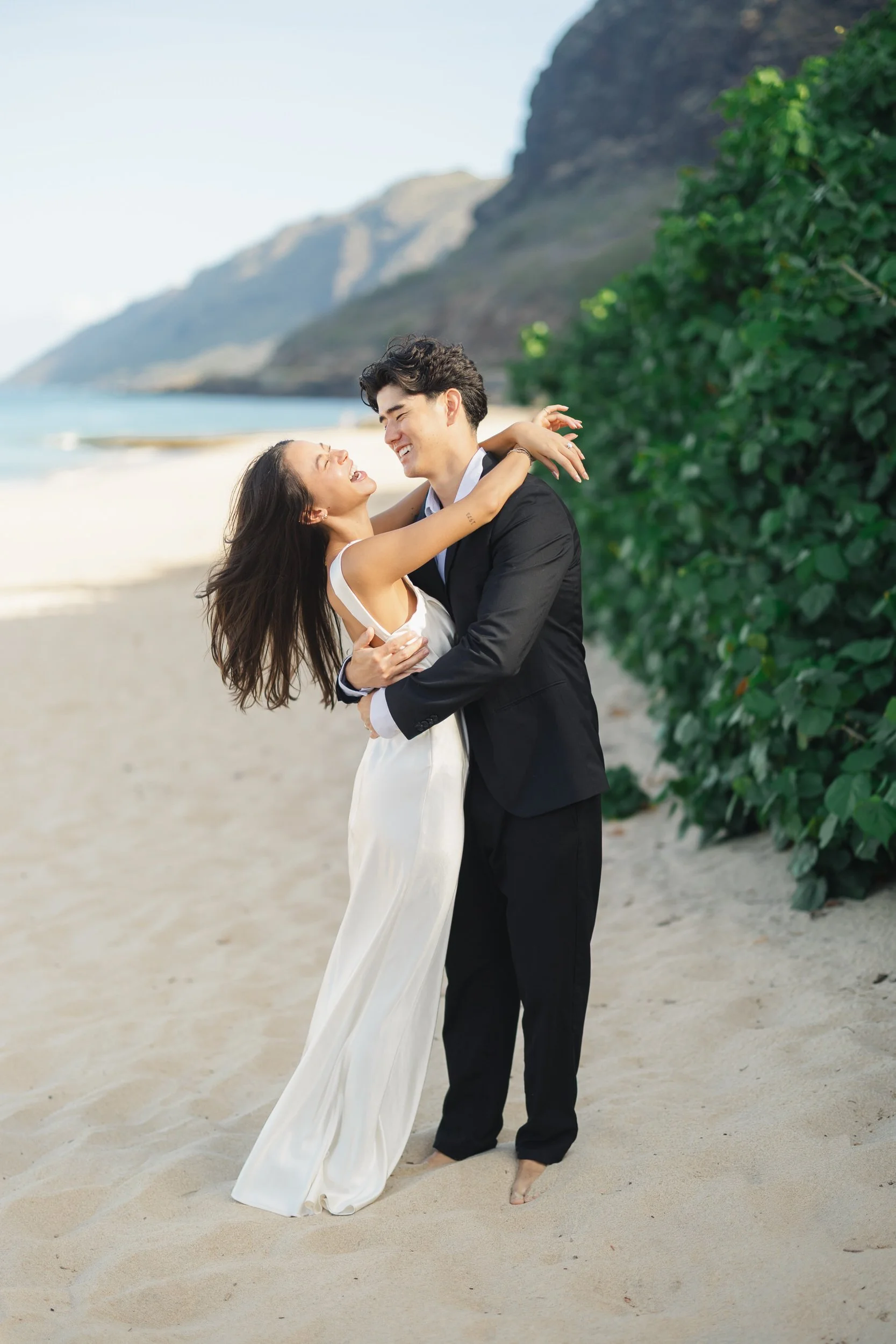 Hawaii elopement couple embracing on Oahu coastline at sunrise
