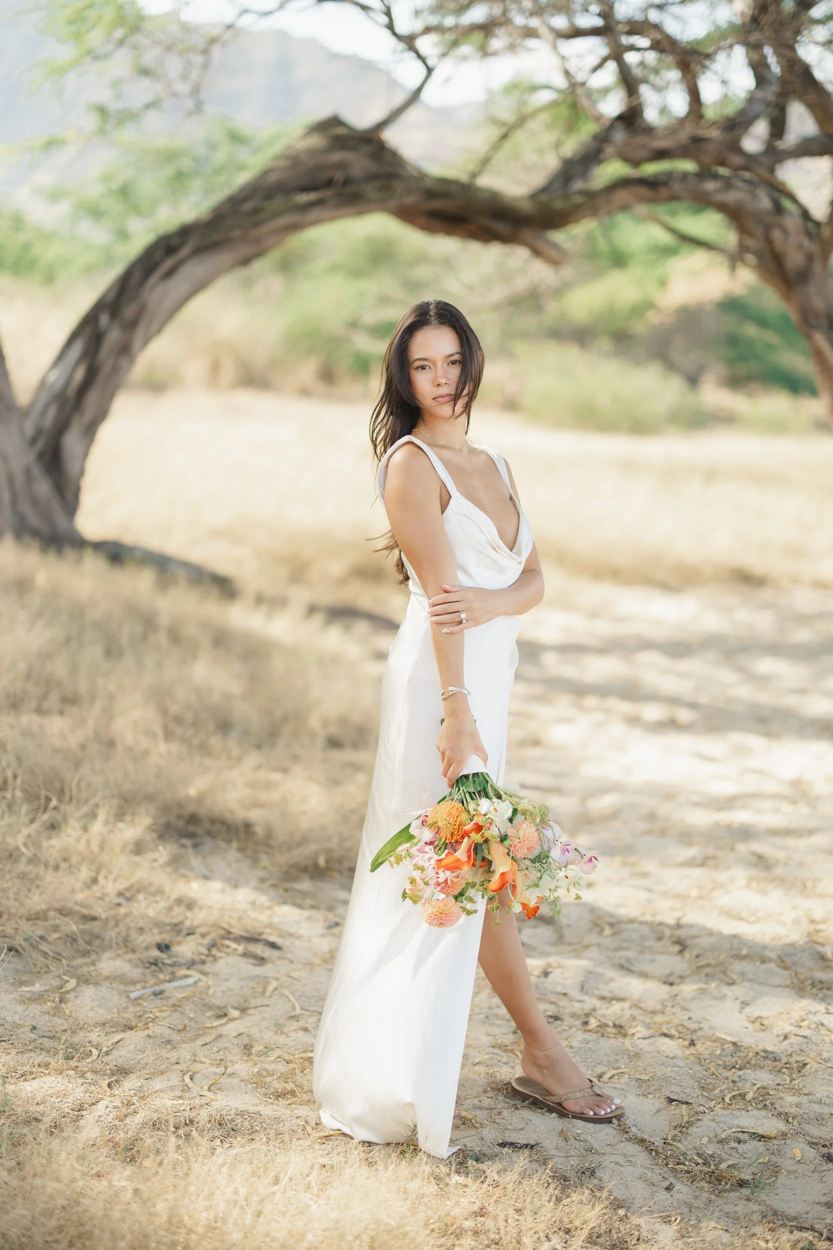 Bride standing on Oahu beach at sunrise during elopement