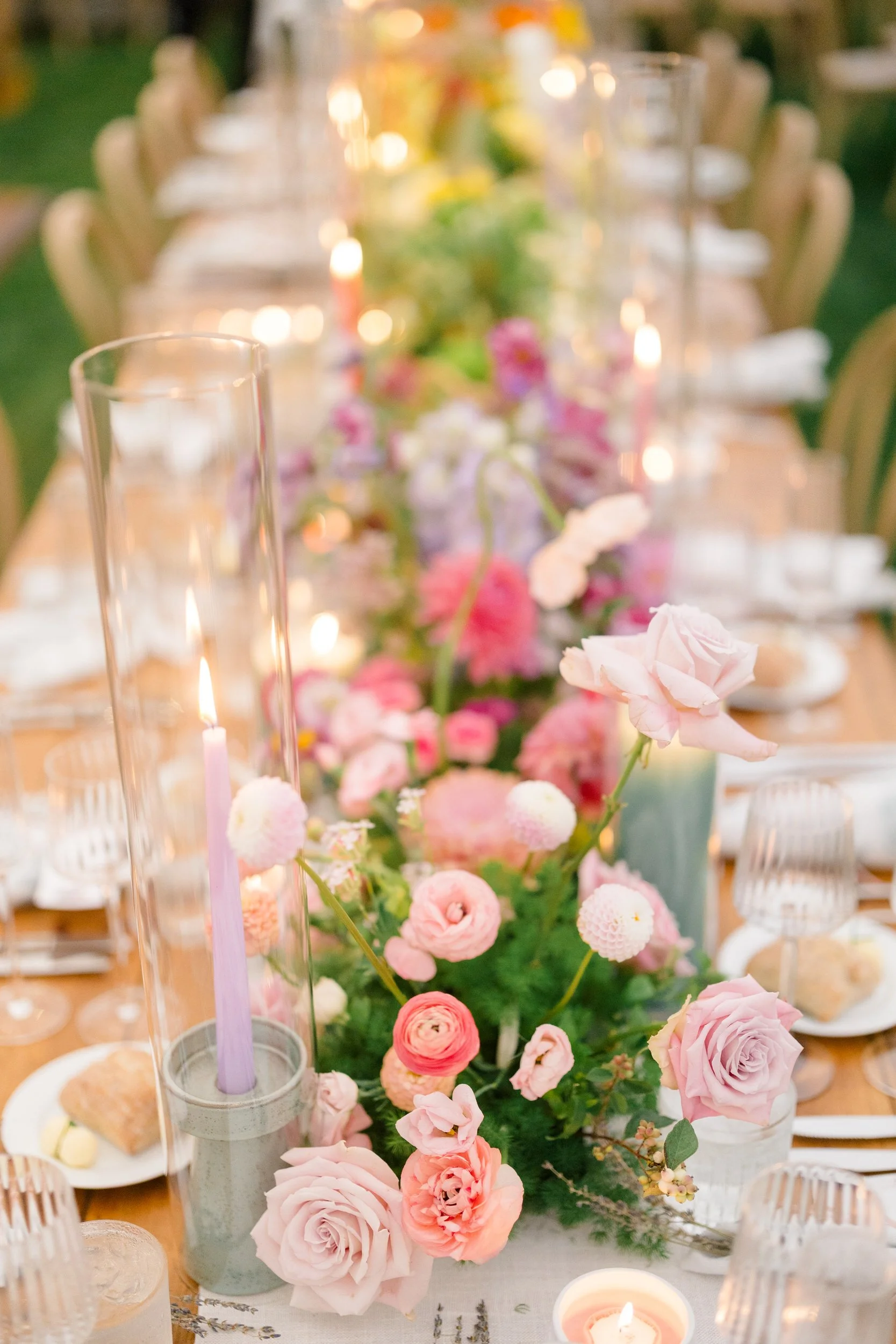 Colorful wedding reception featuring pink, orange, yellow, coral, and red floral arrangements.