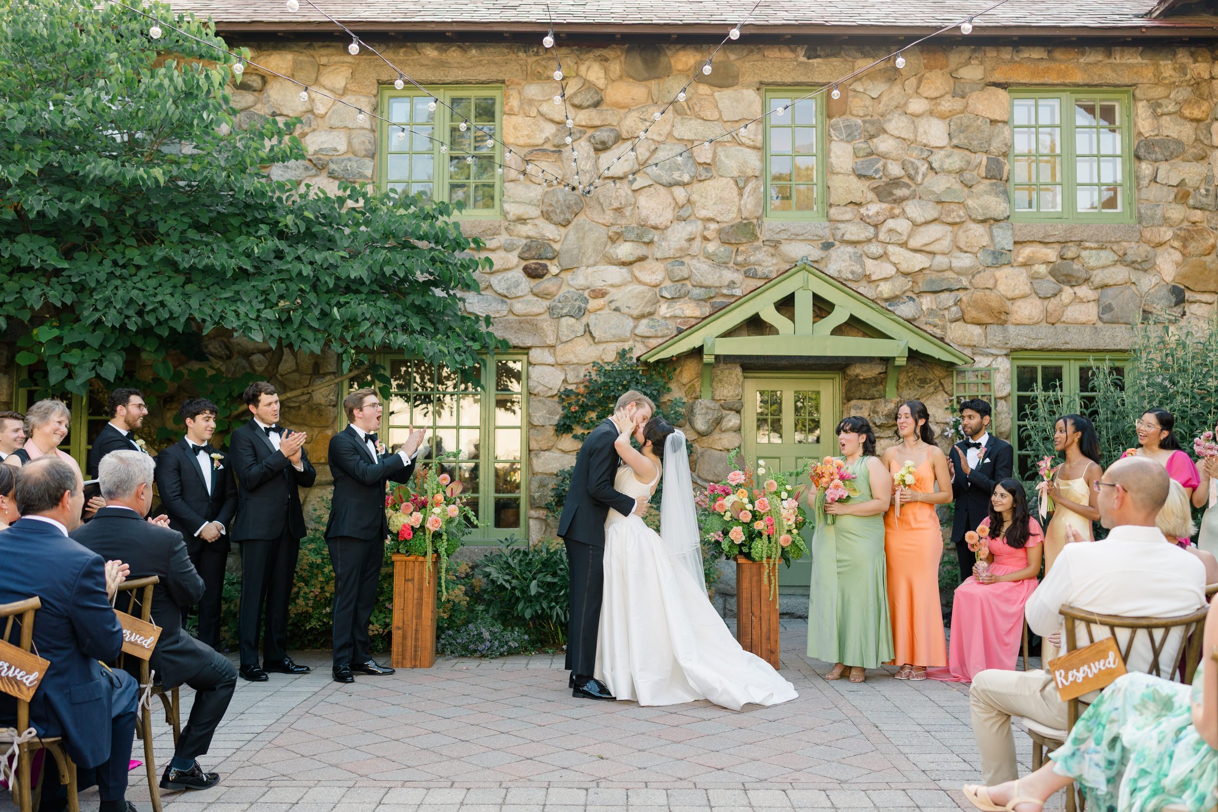 Couple during outdoor ceremony at Willowdale Estate surrounded by vibrant floral design