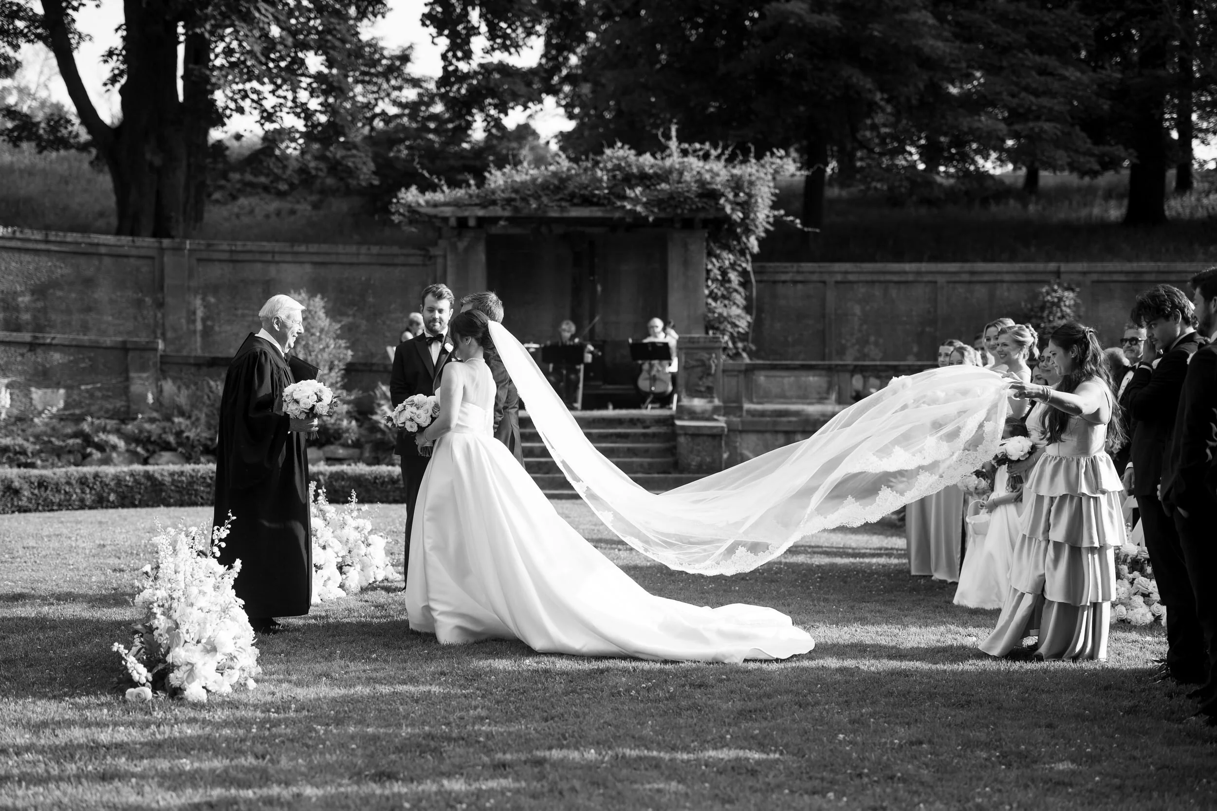Romantic garden wedding ceremony at Castle Hill on the Crane Estate in soft natural light with cathedral length veil.