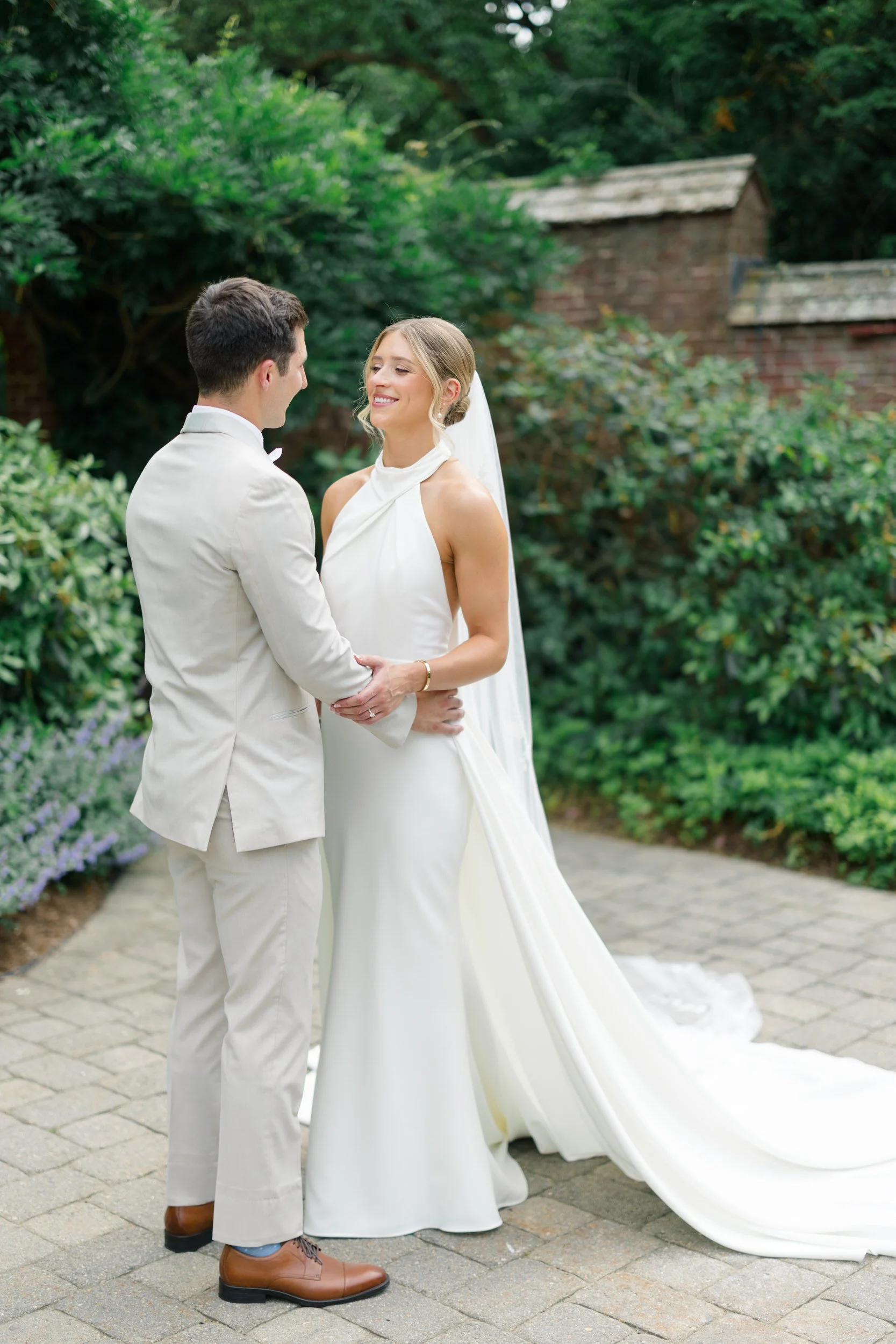 Newlyweds walking through the gardens during golden summer light.