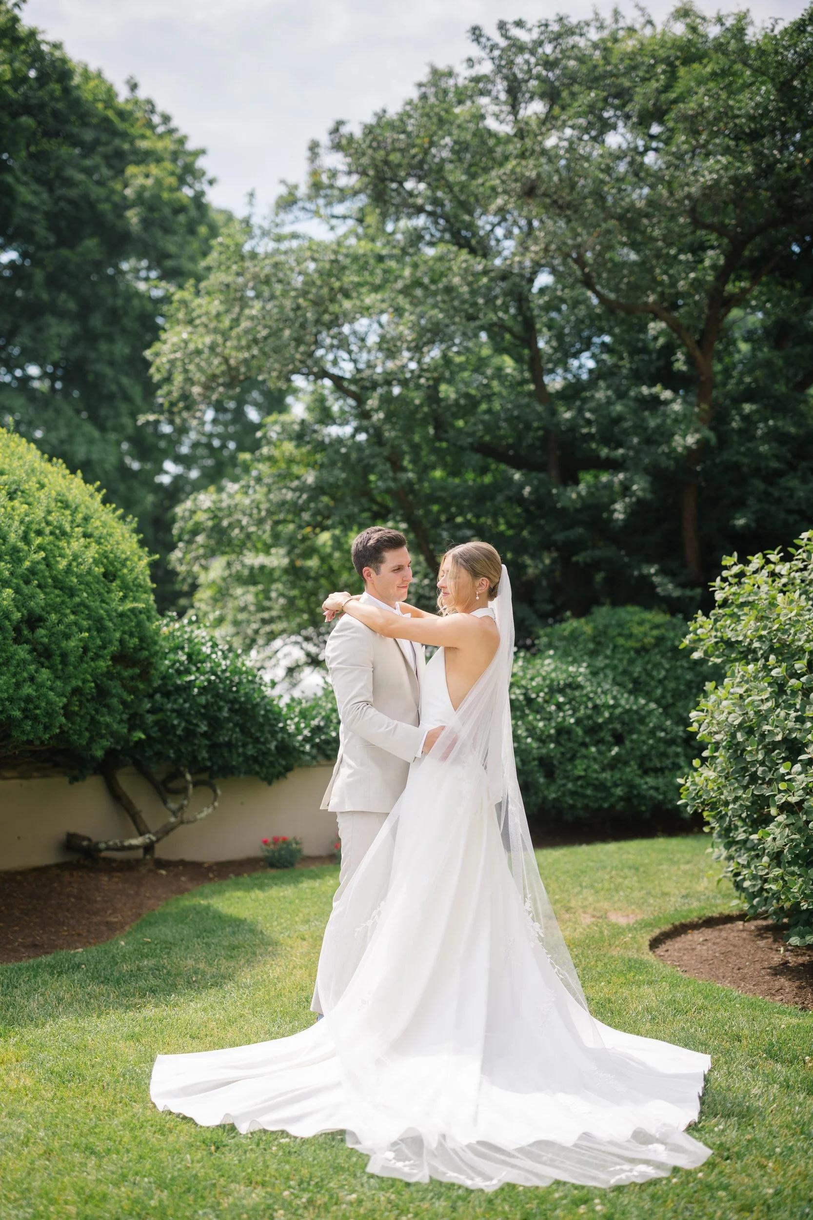 Bride and groom embracing with waterfront views in Beverly, Massachusetts.
