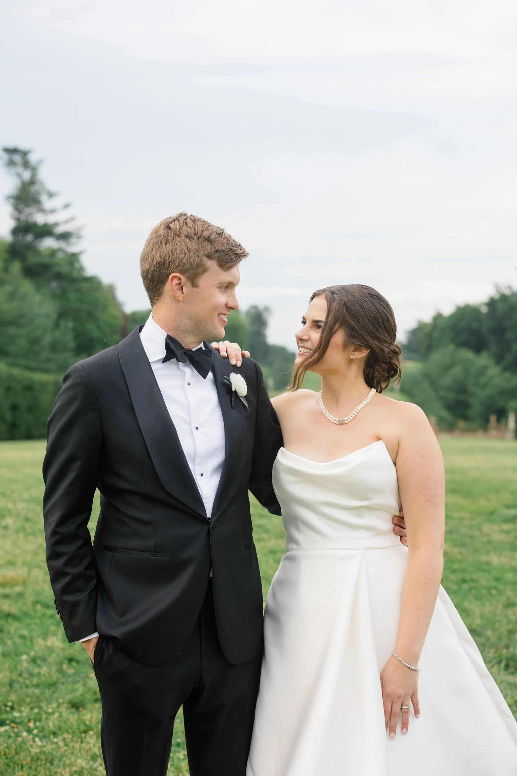 Bride in her Monique Lhuillier gown and groom sharing a quiet moment during sunset at Crane Estate.