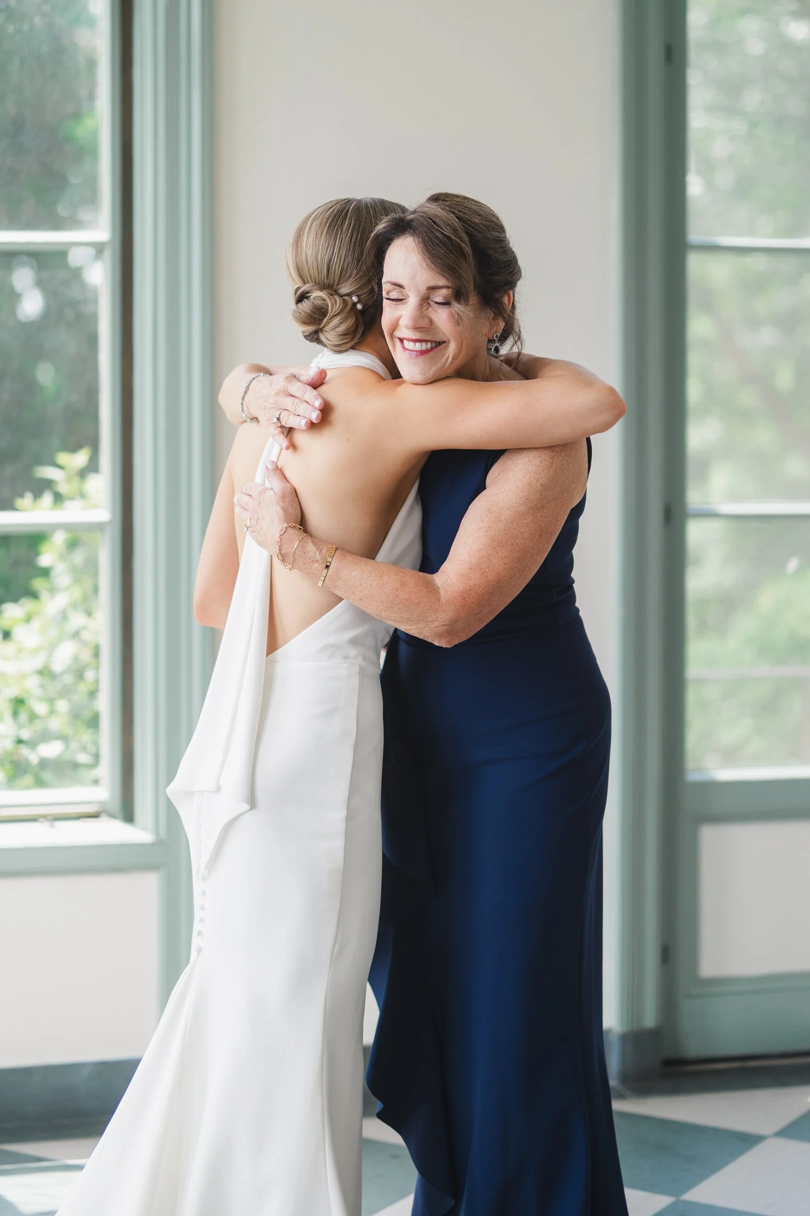 Bride having finishing touches applied before a coastal garden party wedding.