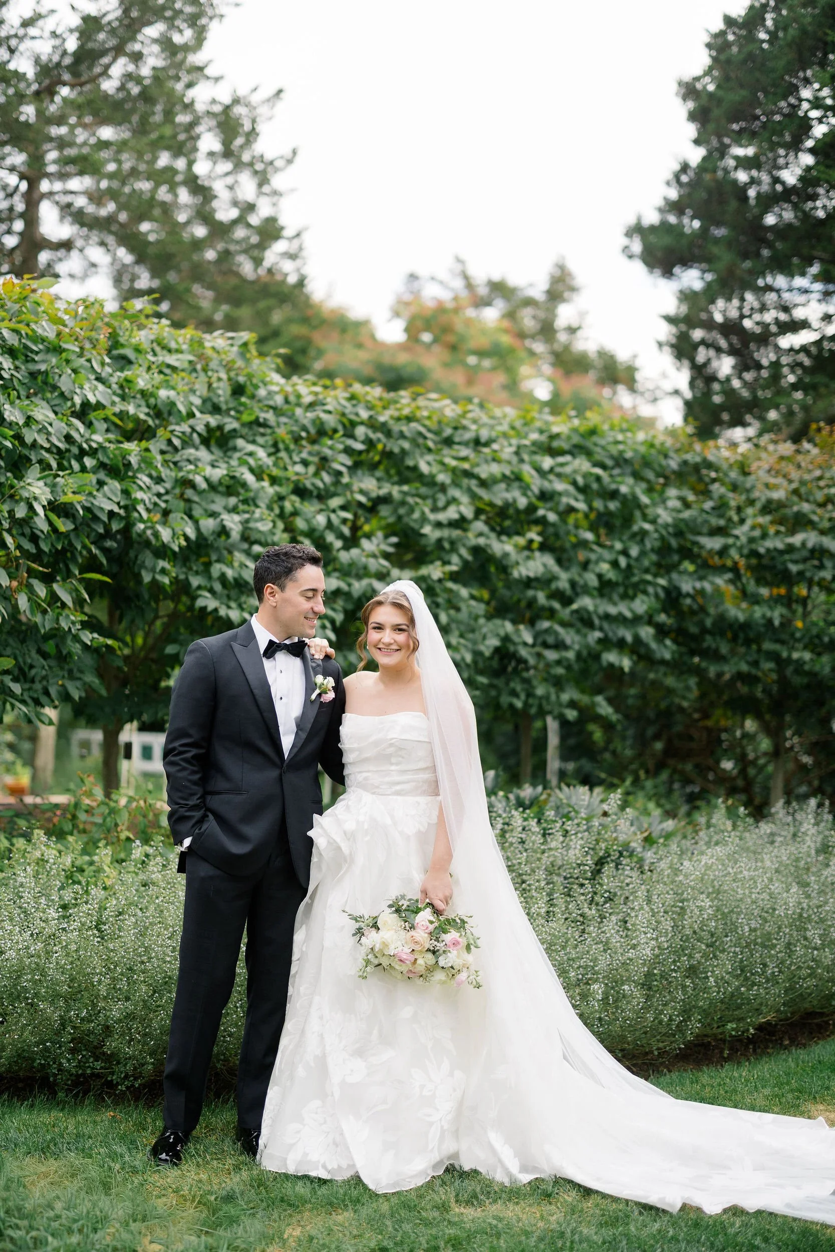 Newlyweds framed by trees and greenery at Long Hill.