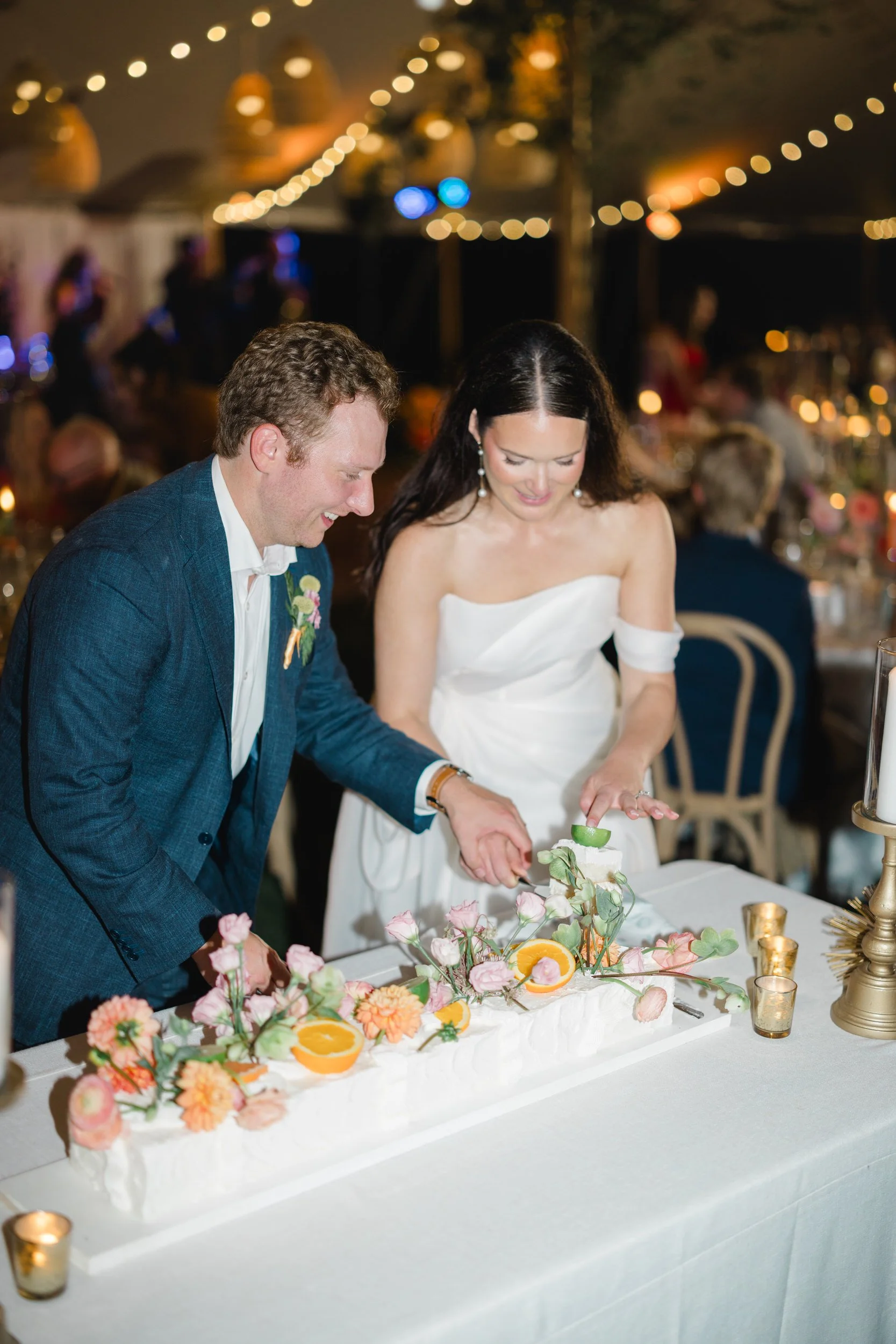 Bride and groom cutting their colorful garden-inspired wedding cake.