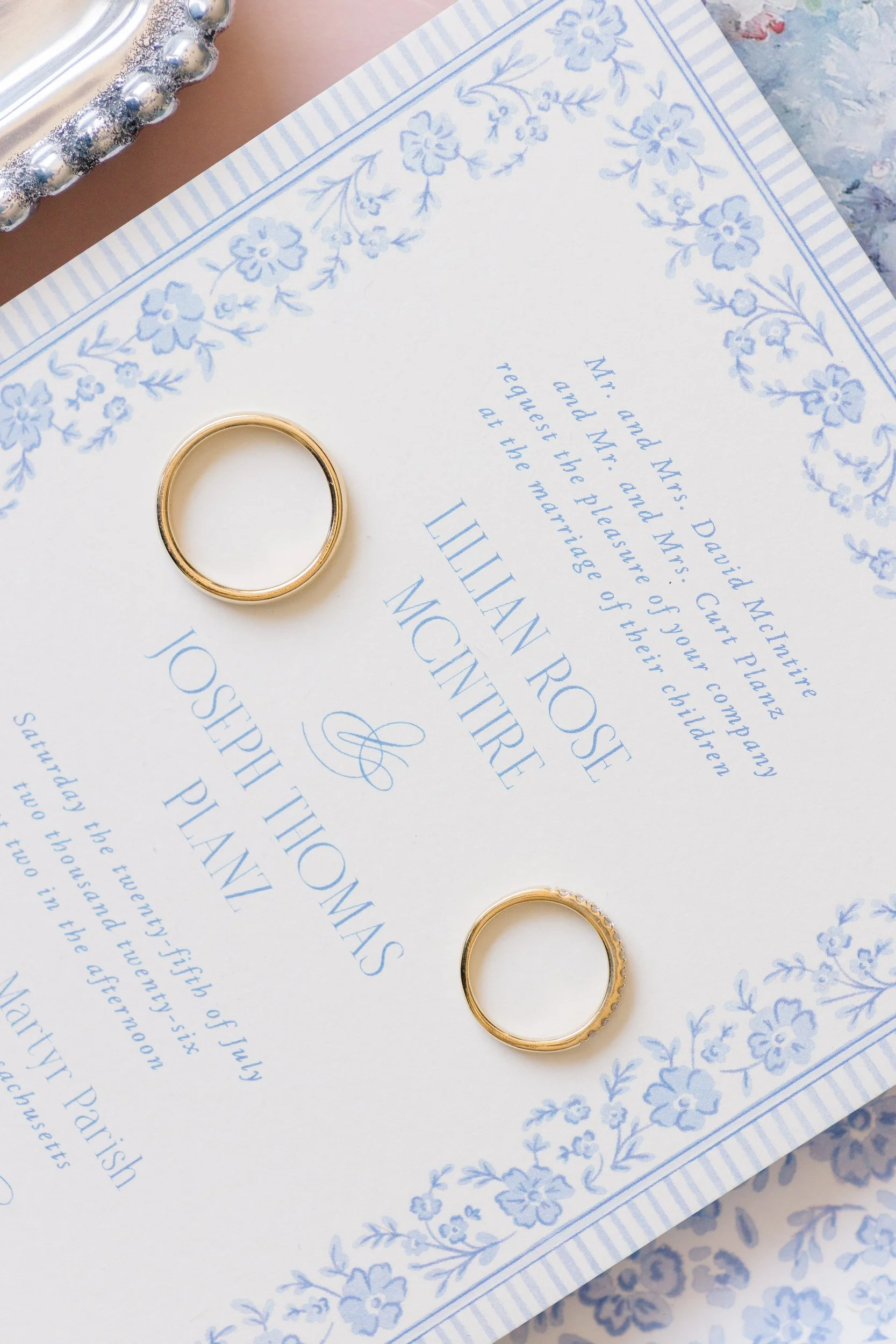Flat lay featuring wedding invitations, rings, and accessories at a luxury Cape Cod private estate wedding.