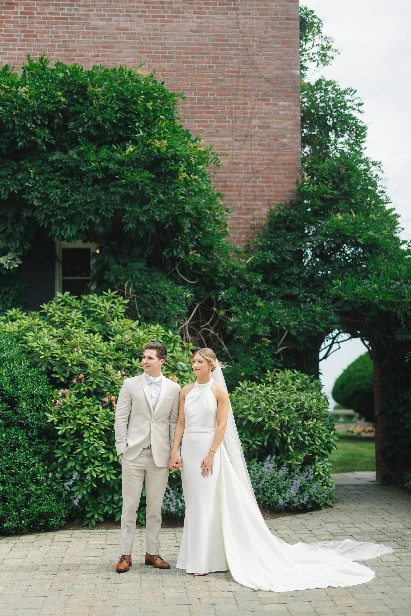 Newlyweds walking through the gardens during golden summer light.
