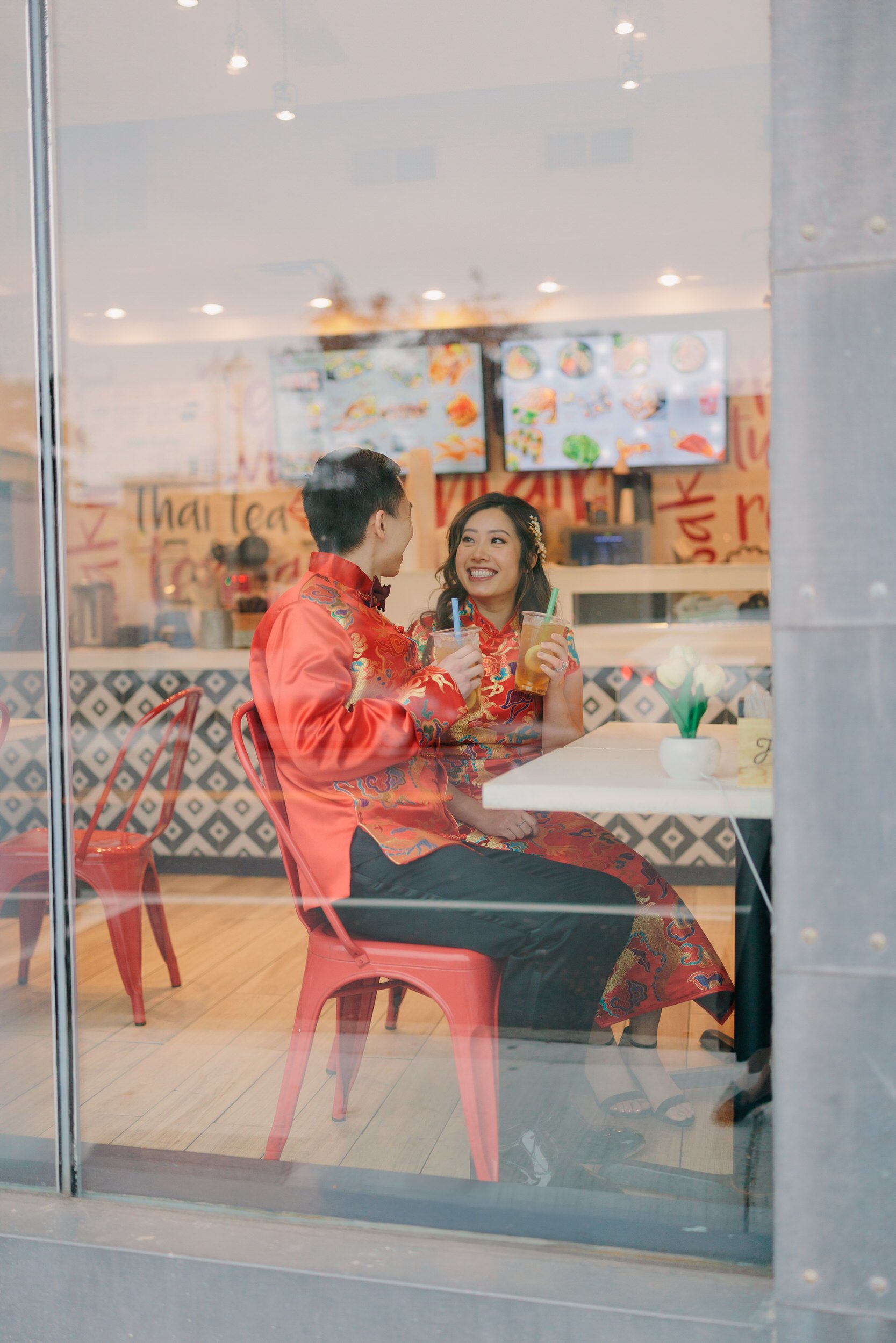 Bride and groom smile and drink tea before their Traditional Chinese Tea Ceremony Wedding in Boston, MA
