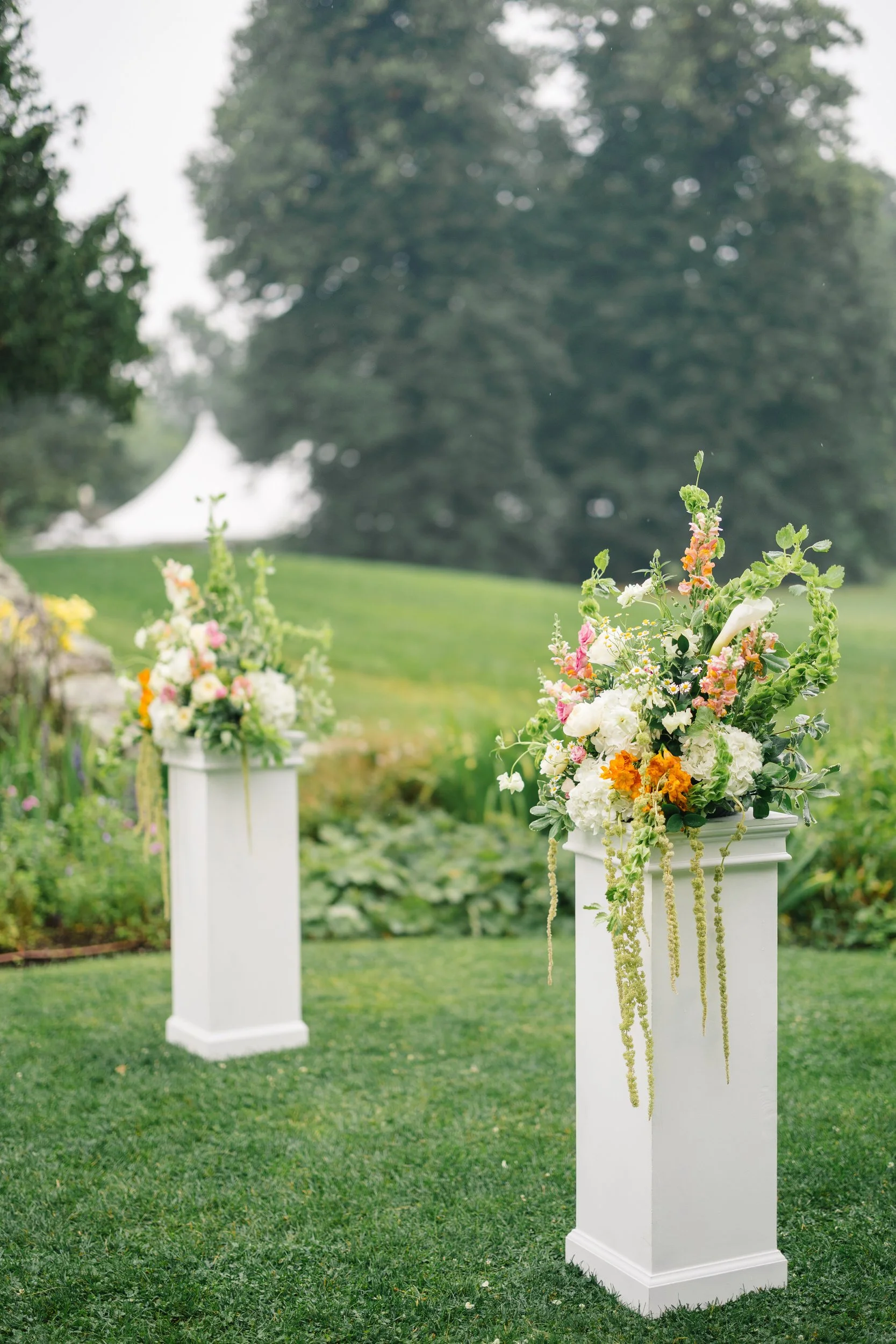 Garden ceremony aisle featuring orange, yellow, pink, and green florals.