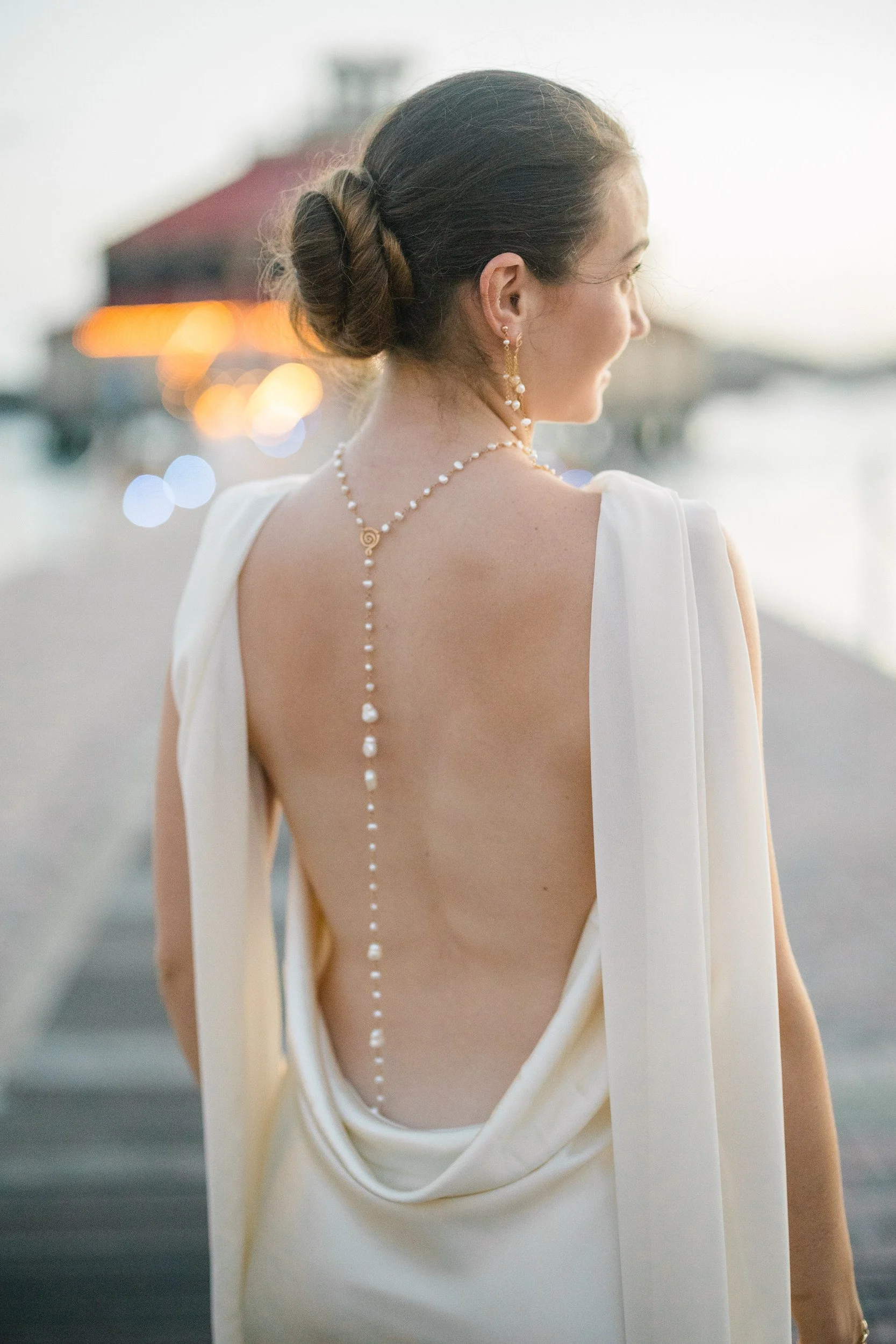 Backless silk gown and long pearl necklace at a St. Thomas rehearsal dinner.