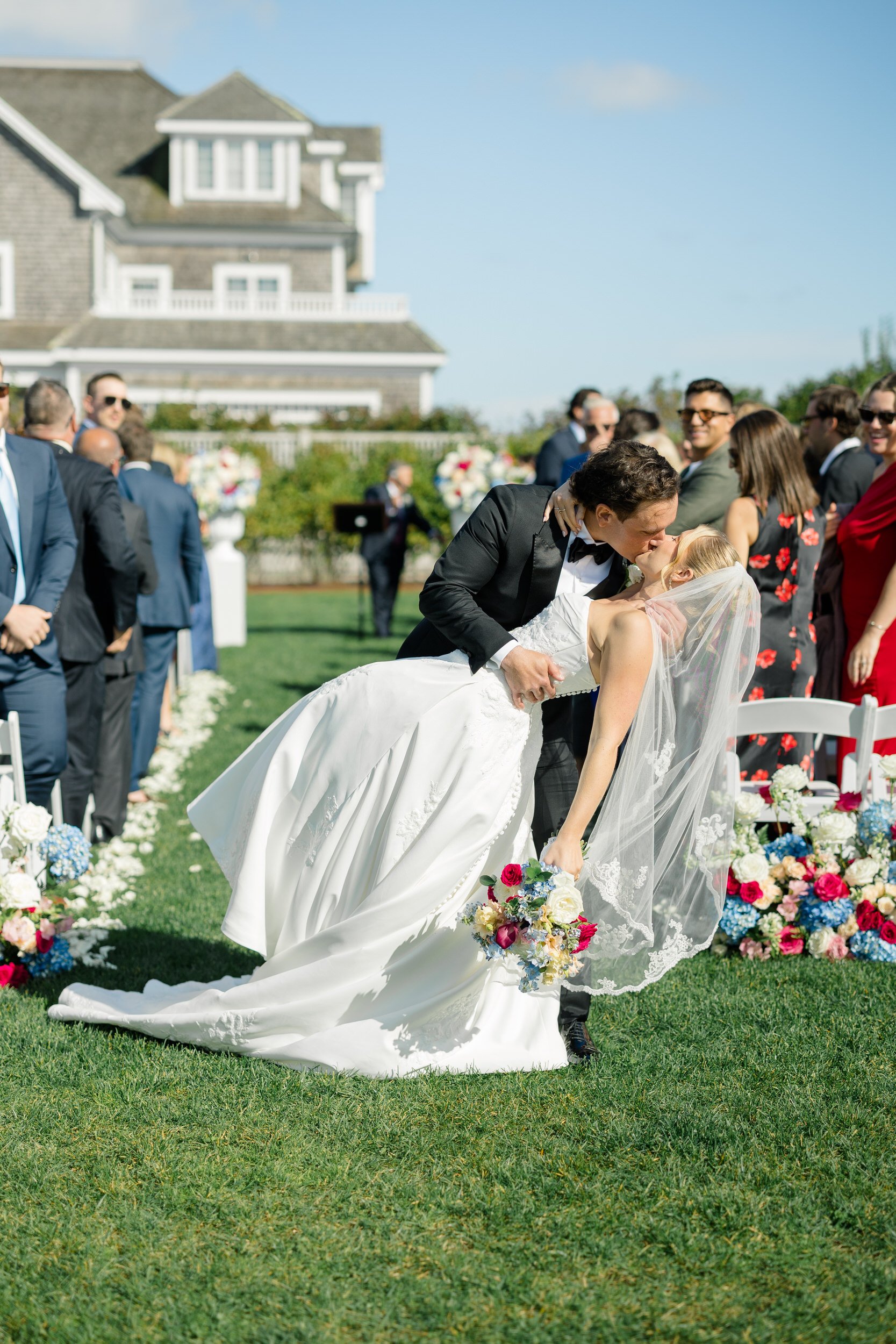 Bride and groom sharing their first kiss as a married couple at Wychmere Beach Club.