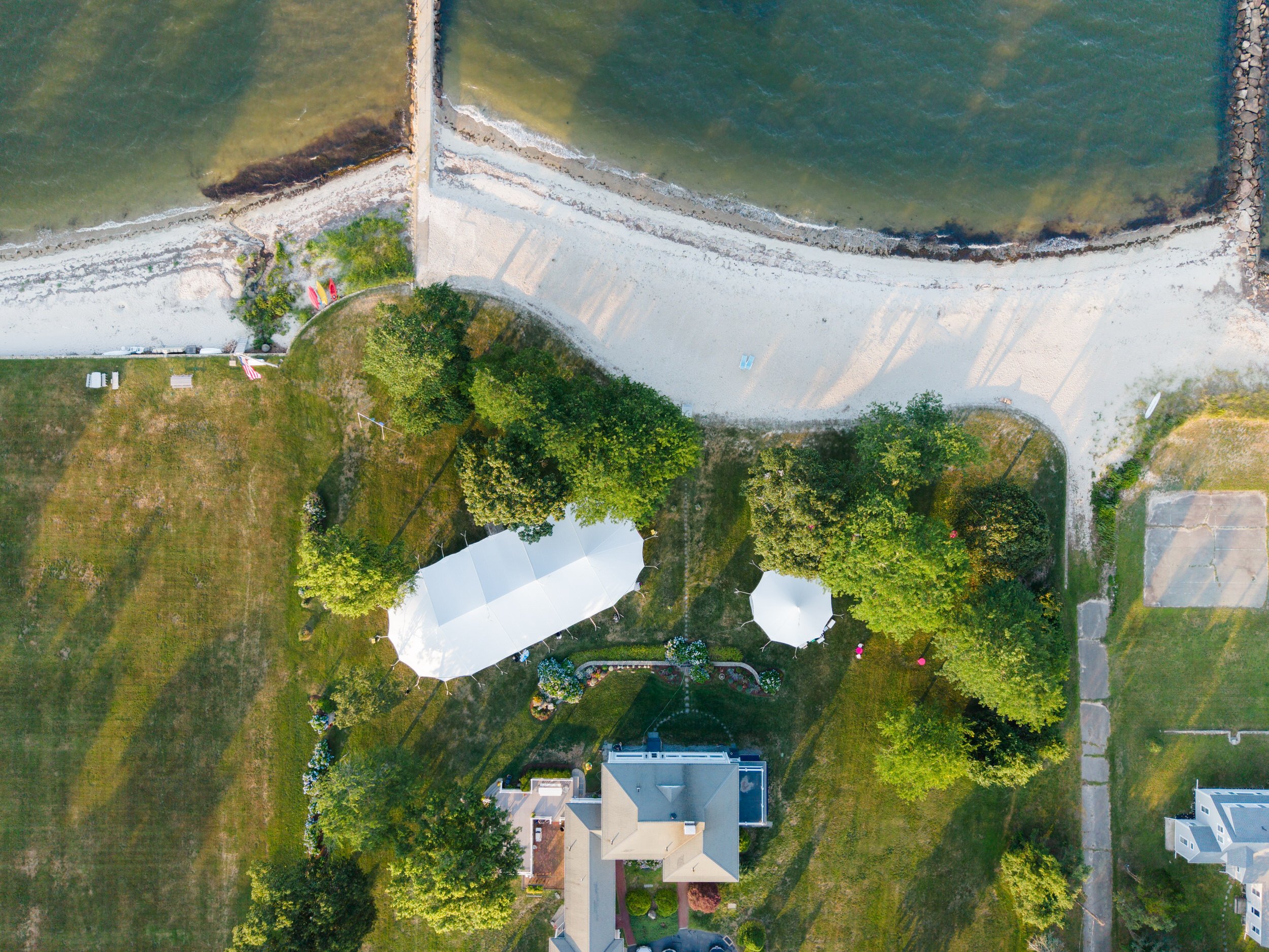 Sunset aerial of a tented private estate wedding.