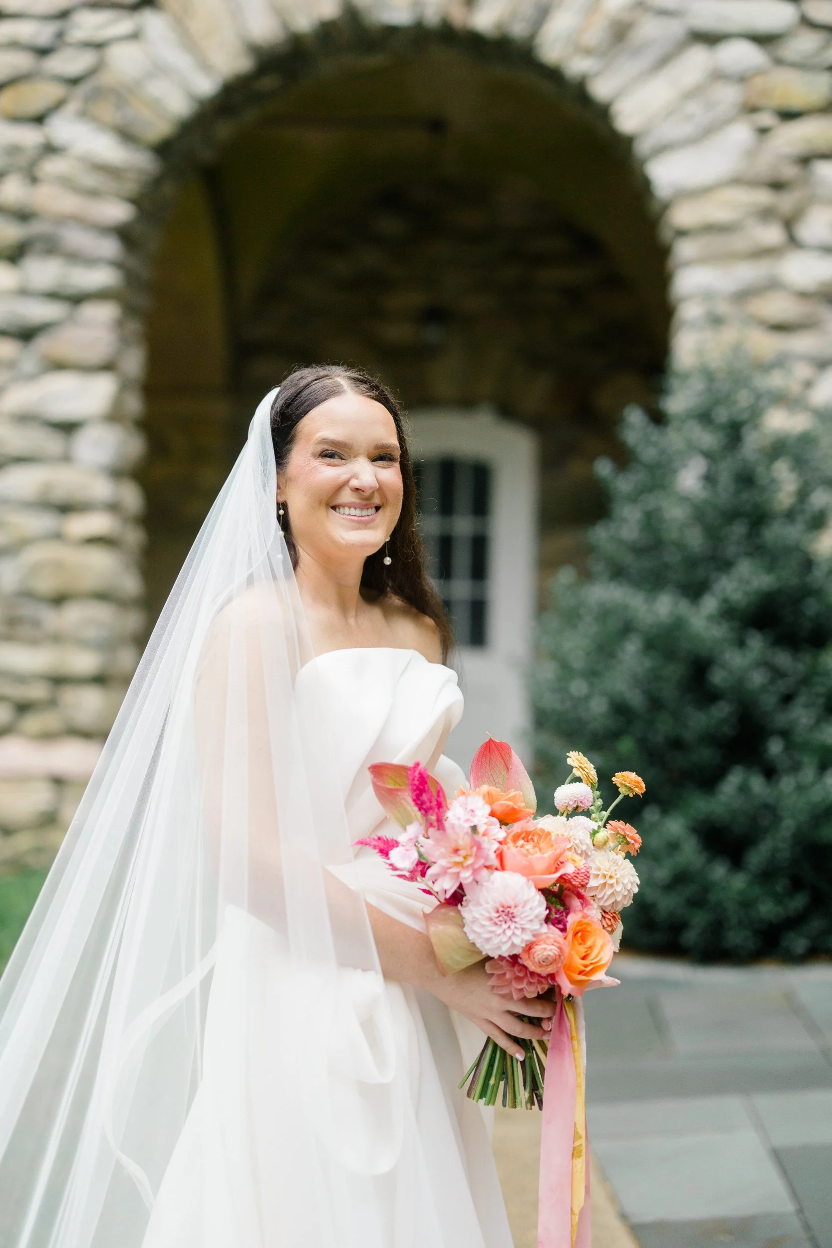 Newlywed portraits surrounded by colorful garden flowers at the Connors Center.