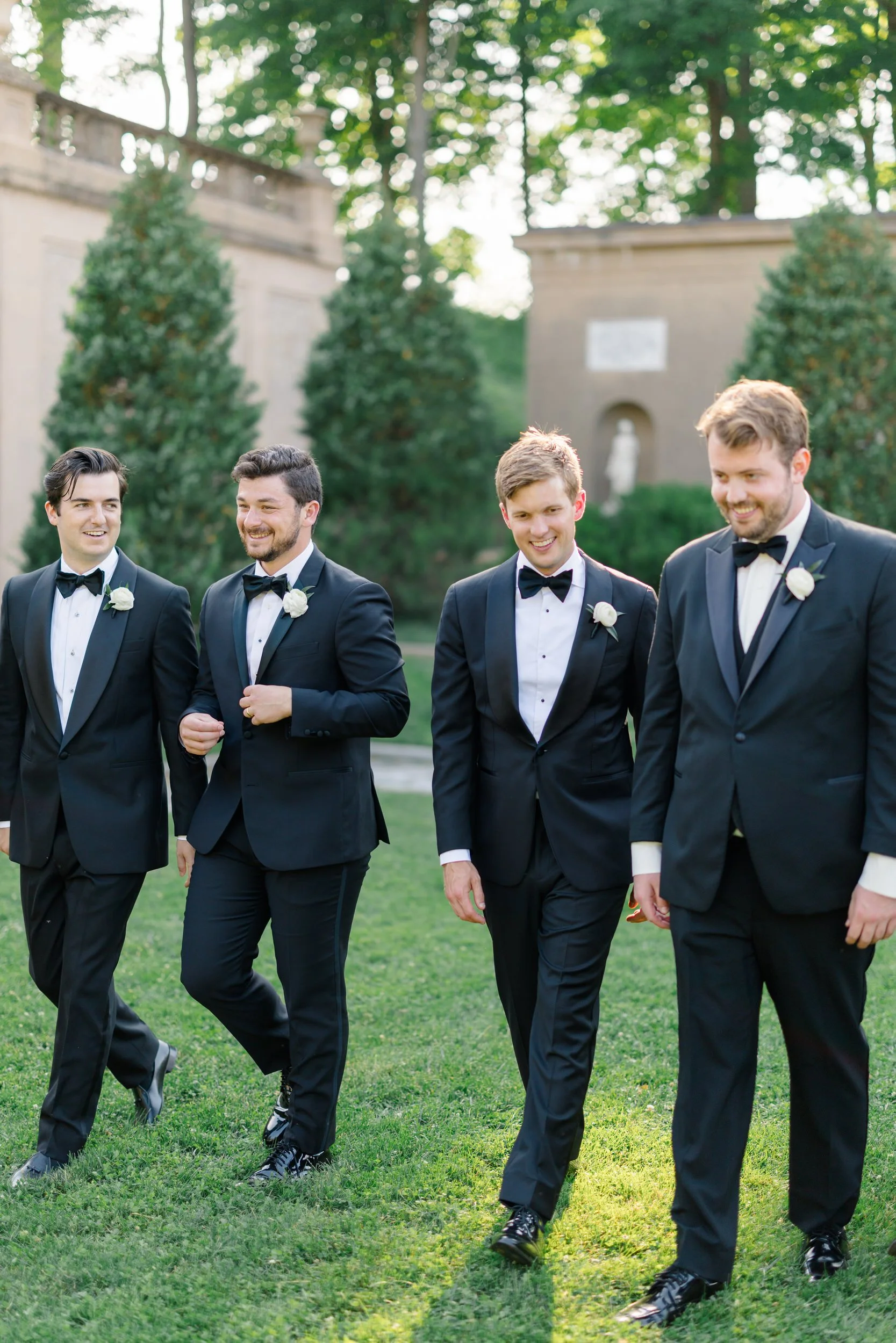 Groom and groomsmen sharing a candid moment outside the historic Casino at Crane Estate.