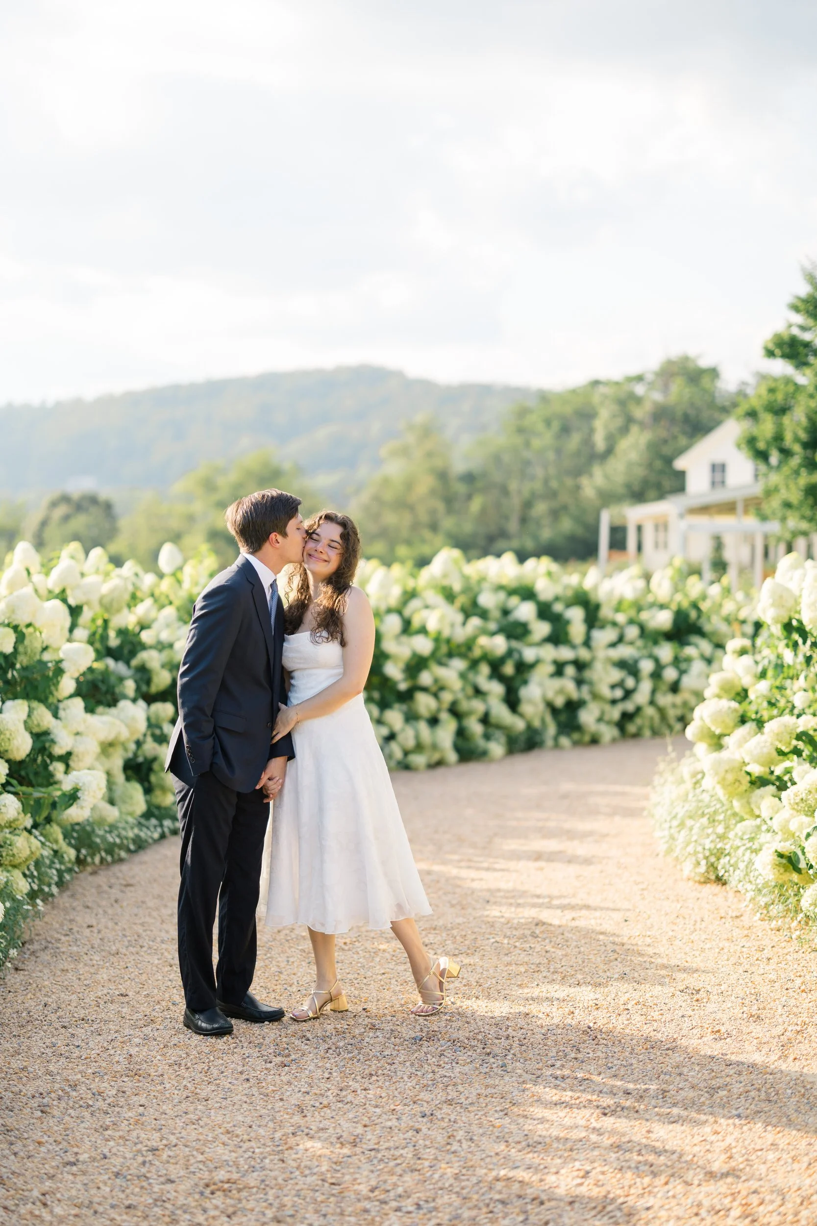 Couple embracing among the white hydrangeas at Pippin Hill Farm & Vineyards in Virginia