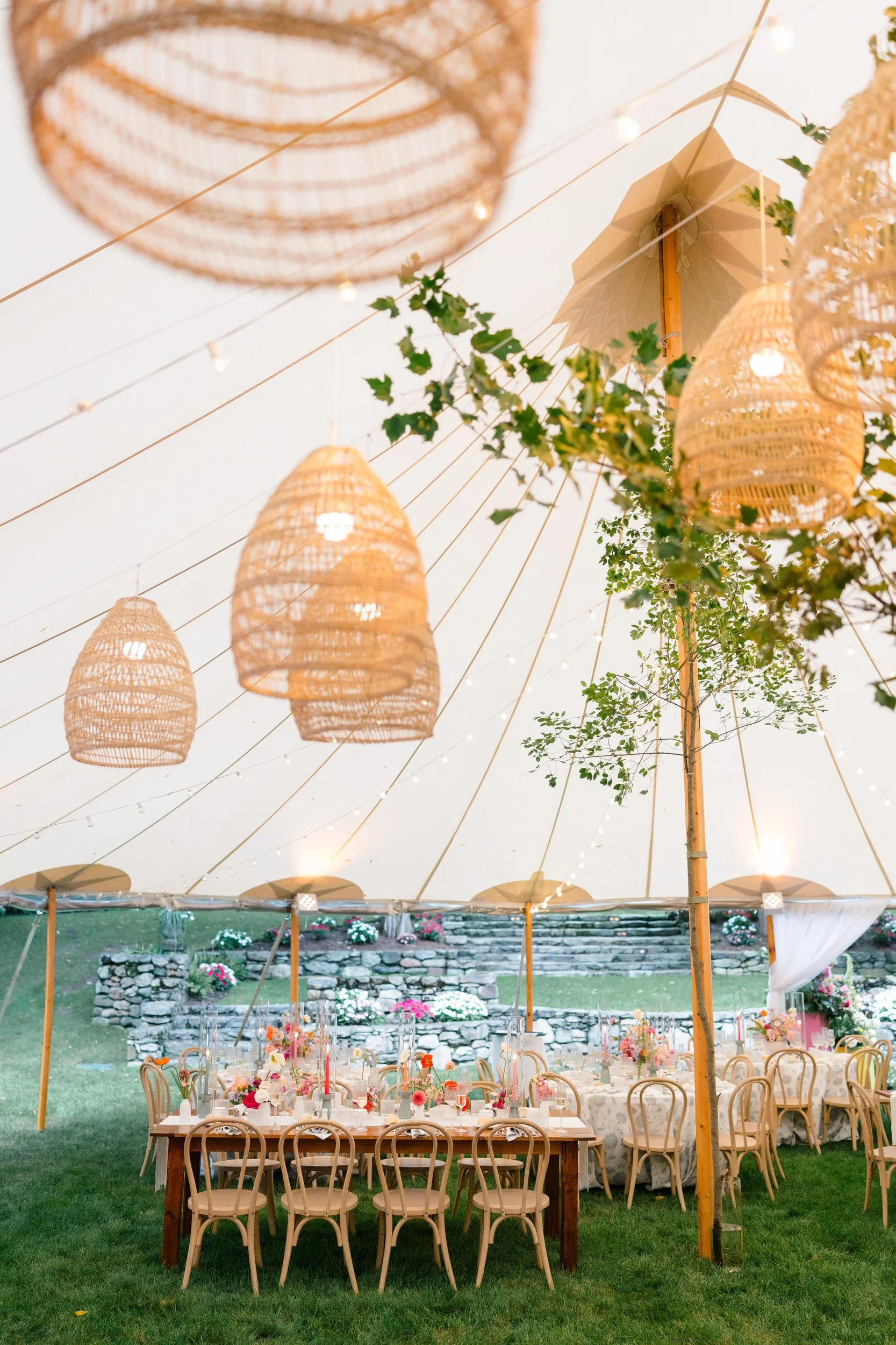 Colorful wedding reception featuring pink, orange, yellow, coral, and red floral arrangements.