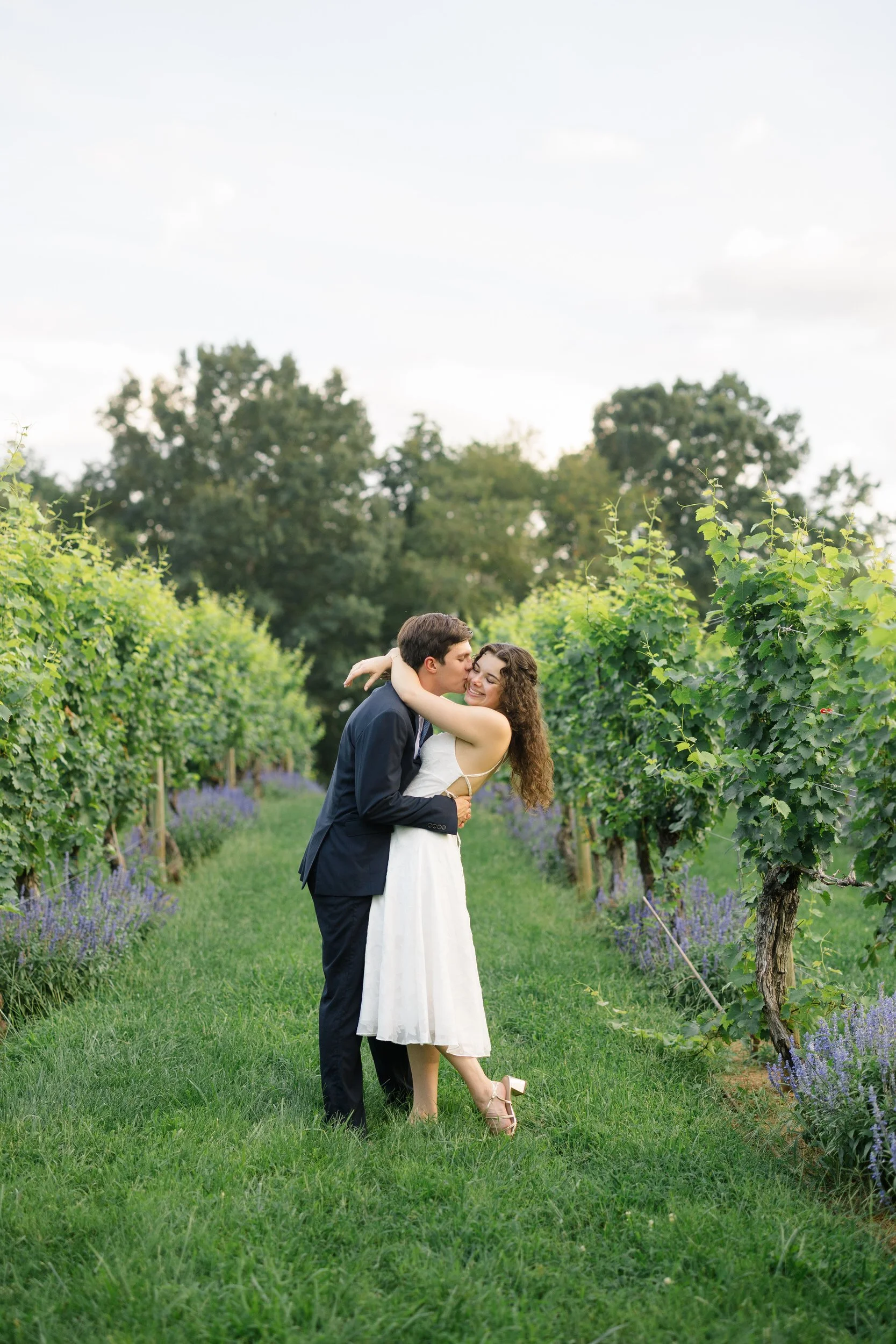 Couple walking between the grapevines during a Virginia wine country engagement session