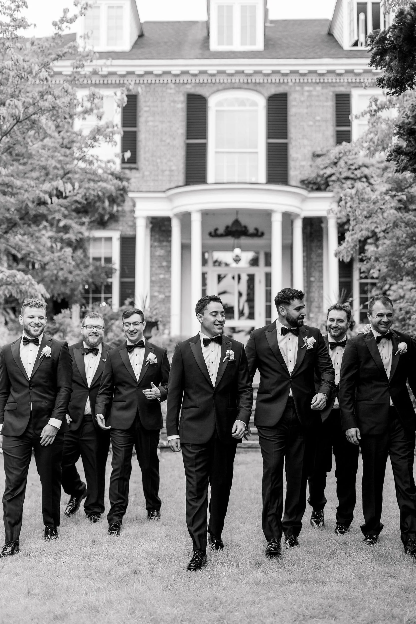 Groom posing with his groomsmen on the grounds of Long Hill estate.