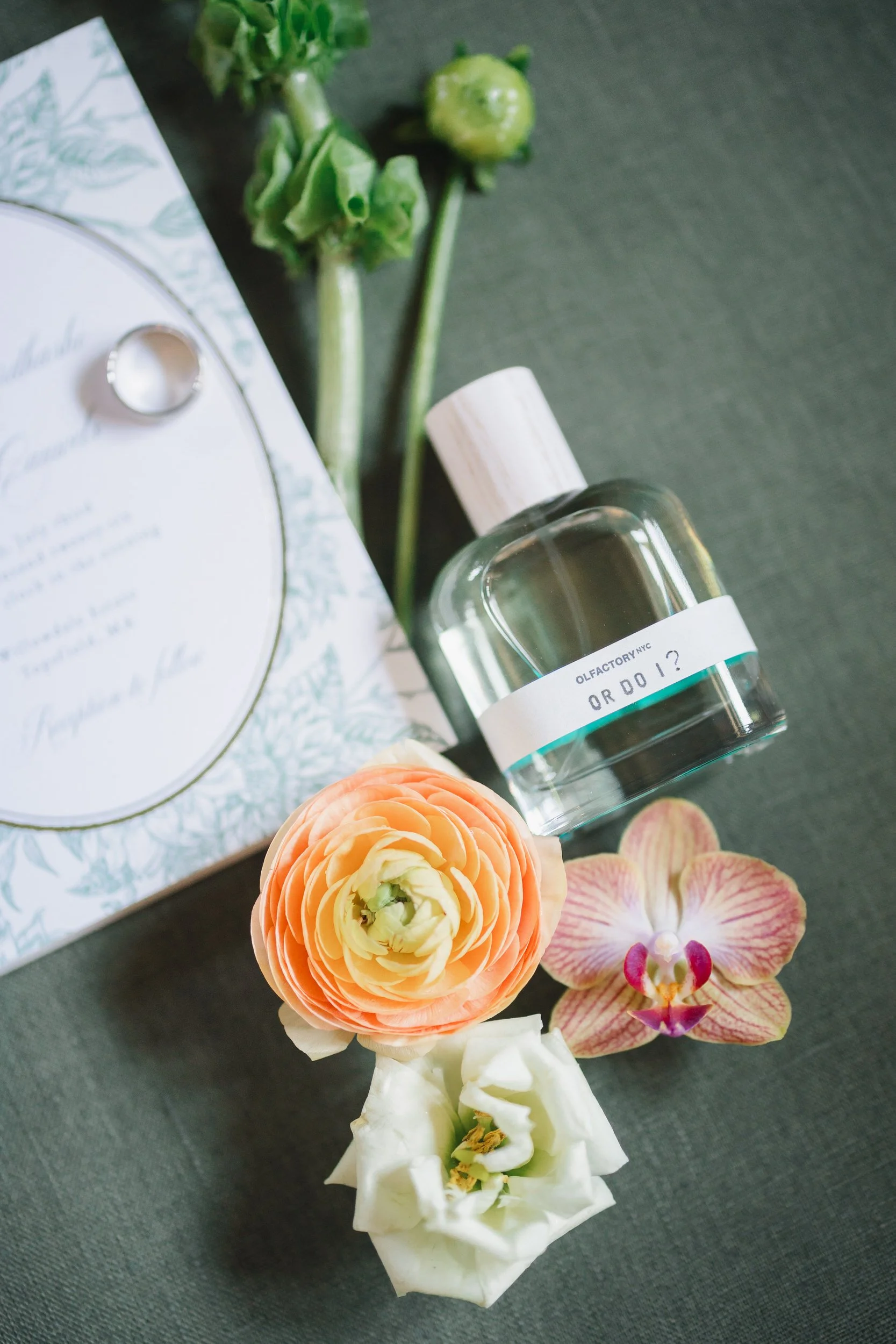 Wedding invitation suite and details styled with pink and orange orchids, dahlias, and ranunculus