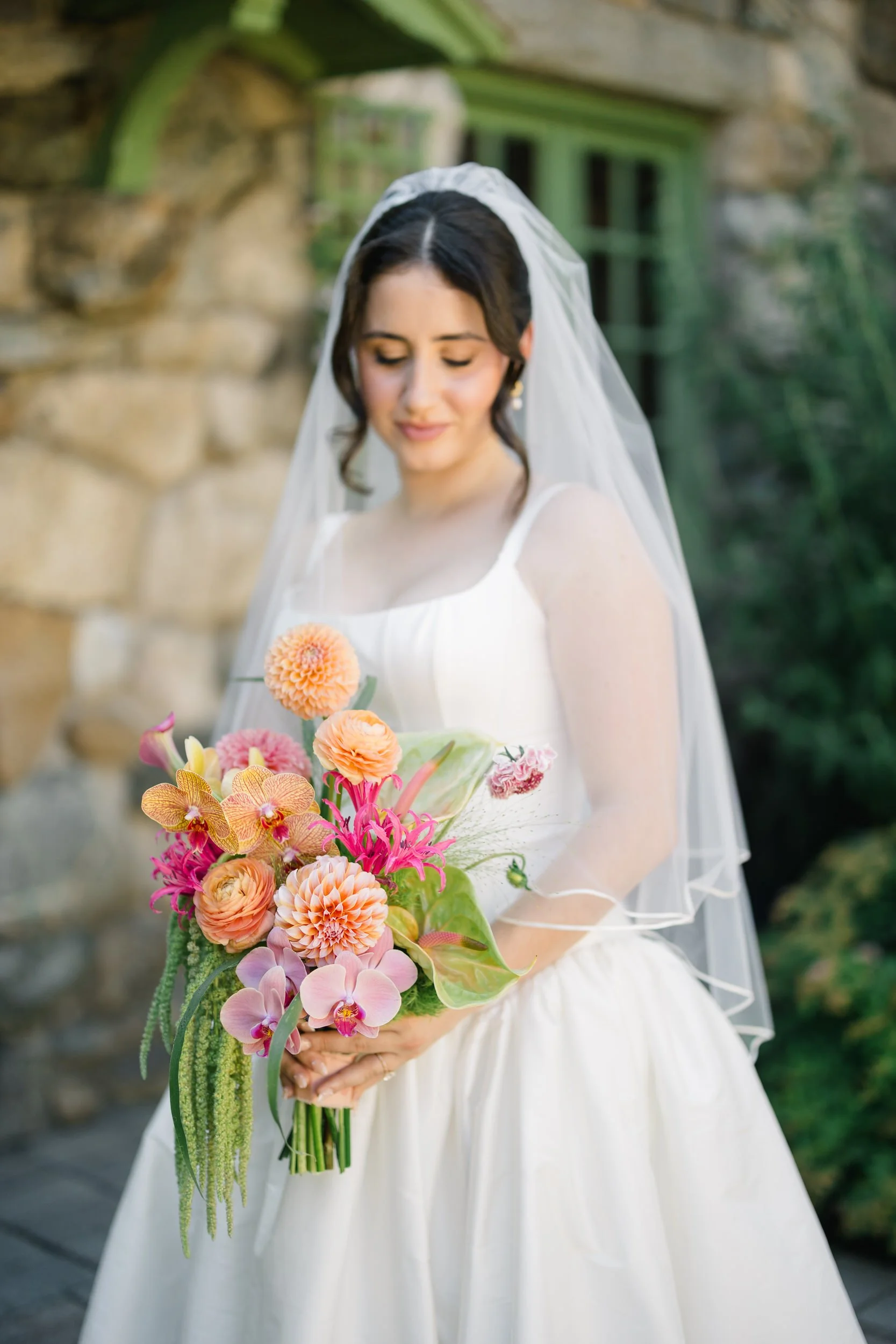 Elegant bridal portrait in lush garden at Willowdale Estate Massachusetts featuring timeless basque waist gown and soft veil movement