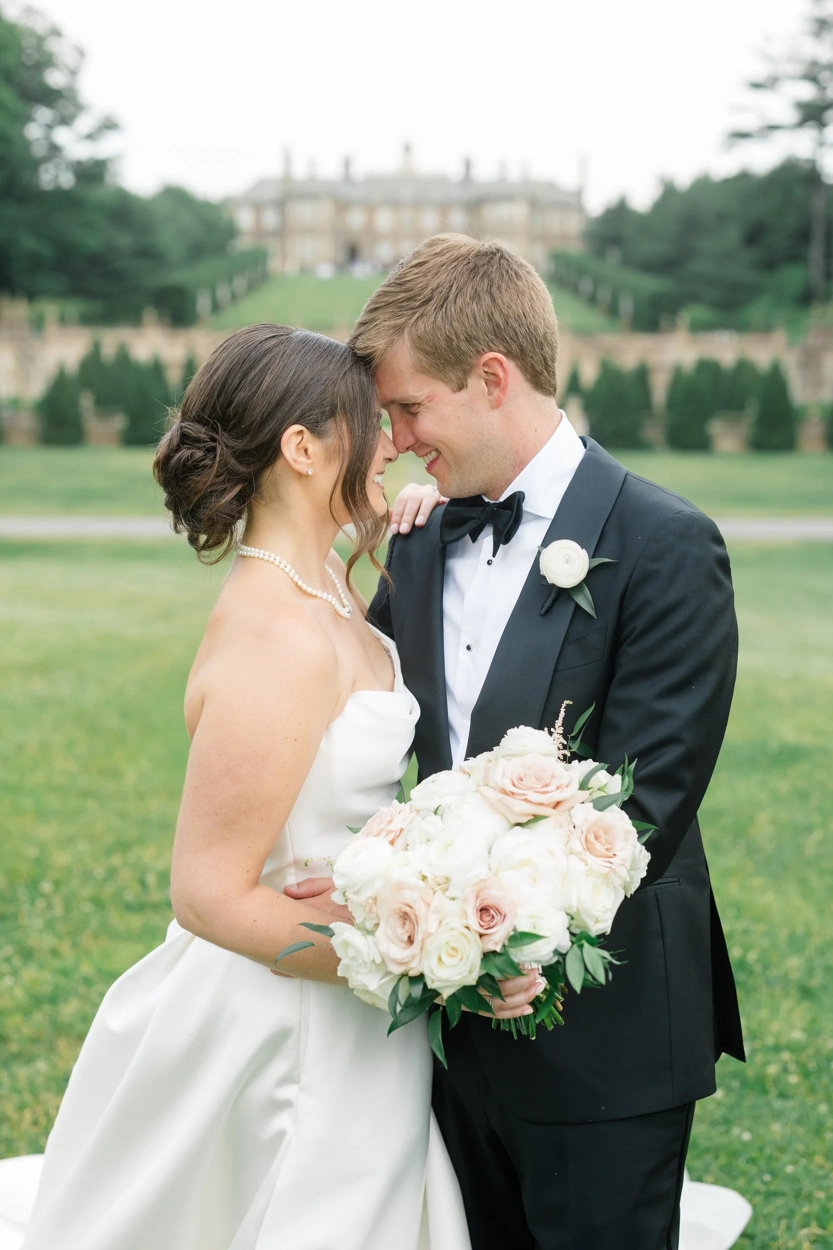 Bride in her Monique Lhuillier gown and groom sharing a quiet moment during sunset at Crane Estate.