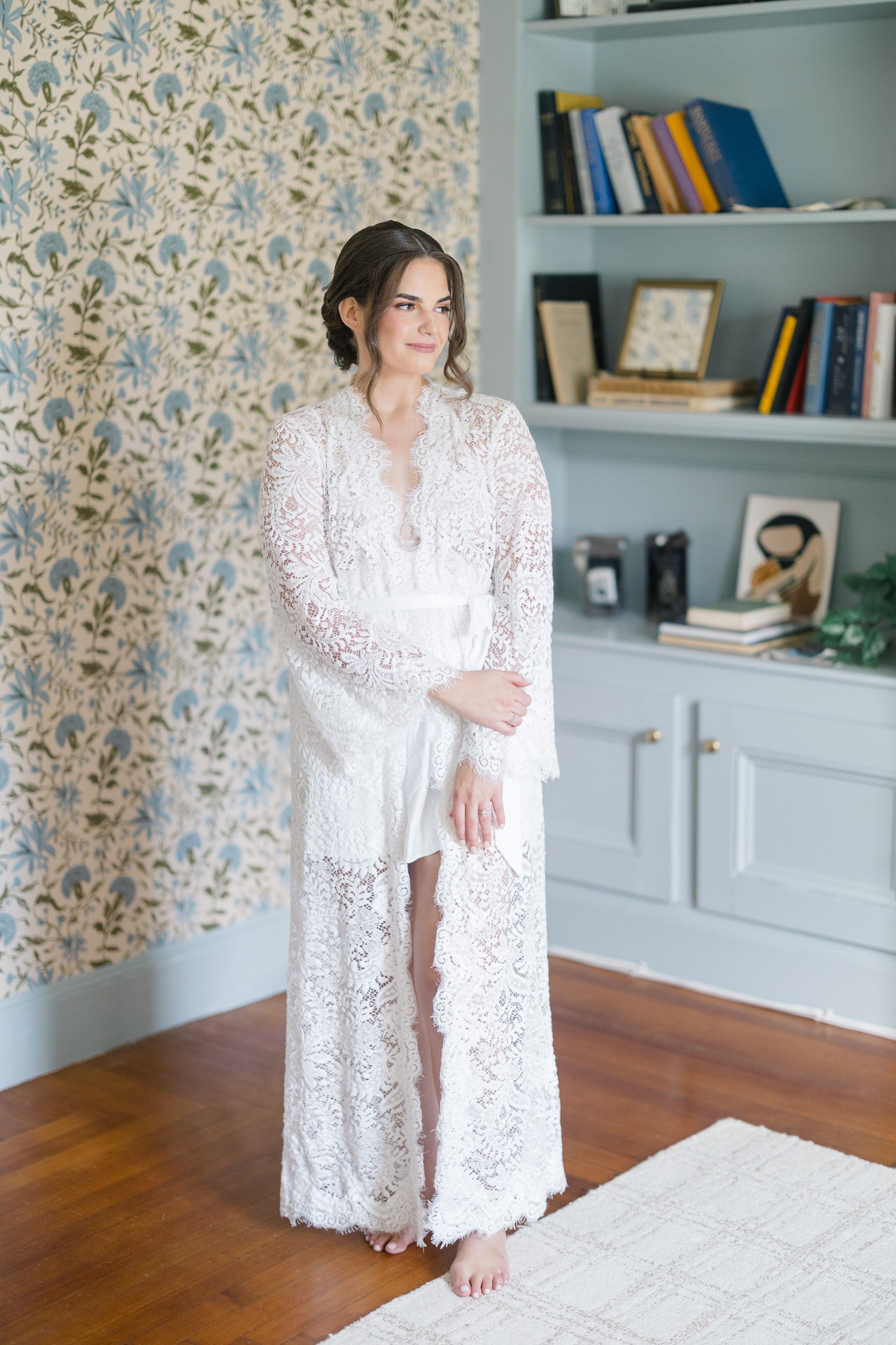 The bride smiling as the finishing touches are added to her hair and makeup before her Crane Estate wedding in Ipswich, Massachusetts.
