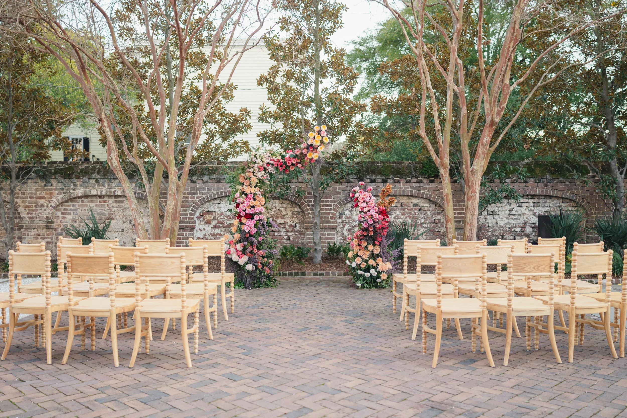 Spring wedding ceremony with pink climbing florals at The Gadsen House in Charleston, South Carolina