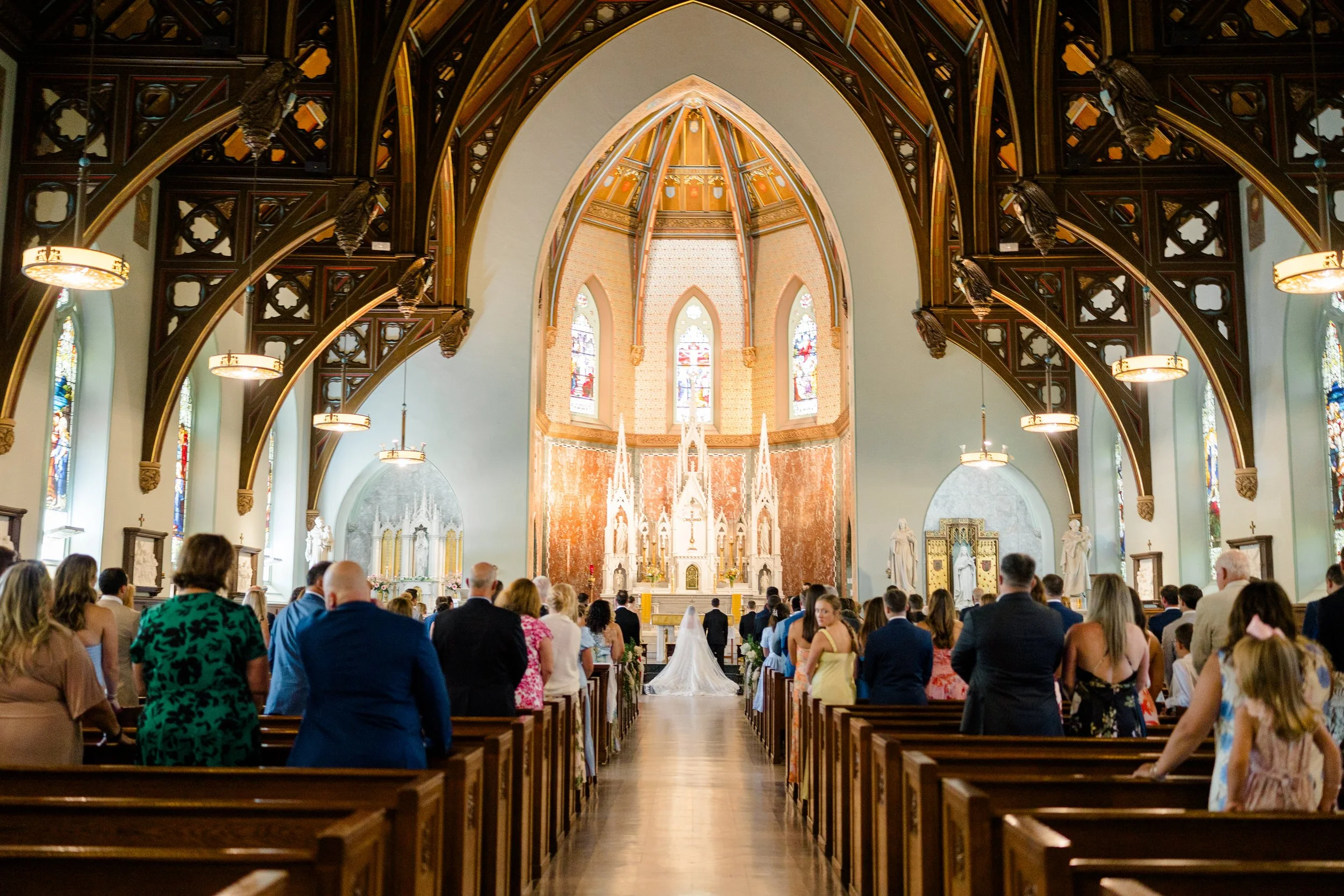 Couple exchanging vows during their Catholic wedding ceremony at St. Lawrence Martyr Parish.