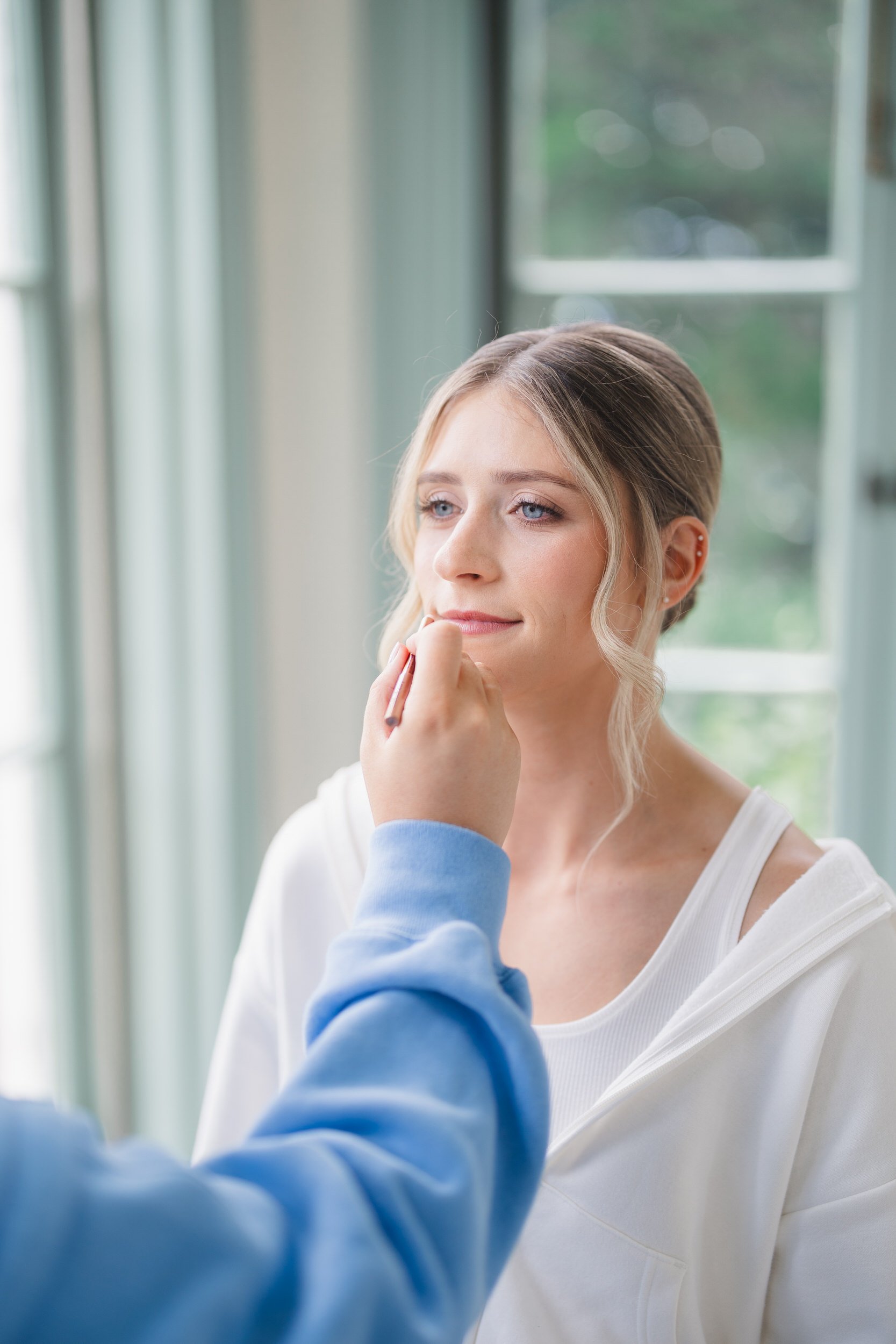 Bride getting ready in natural light before her summer wedding at Misselwood Estate.