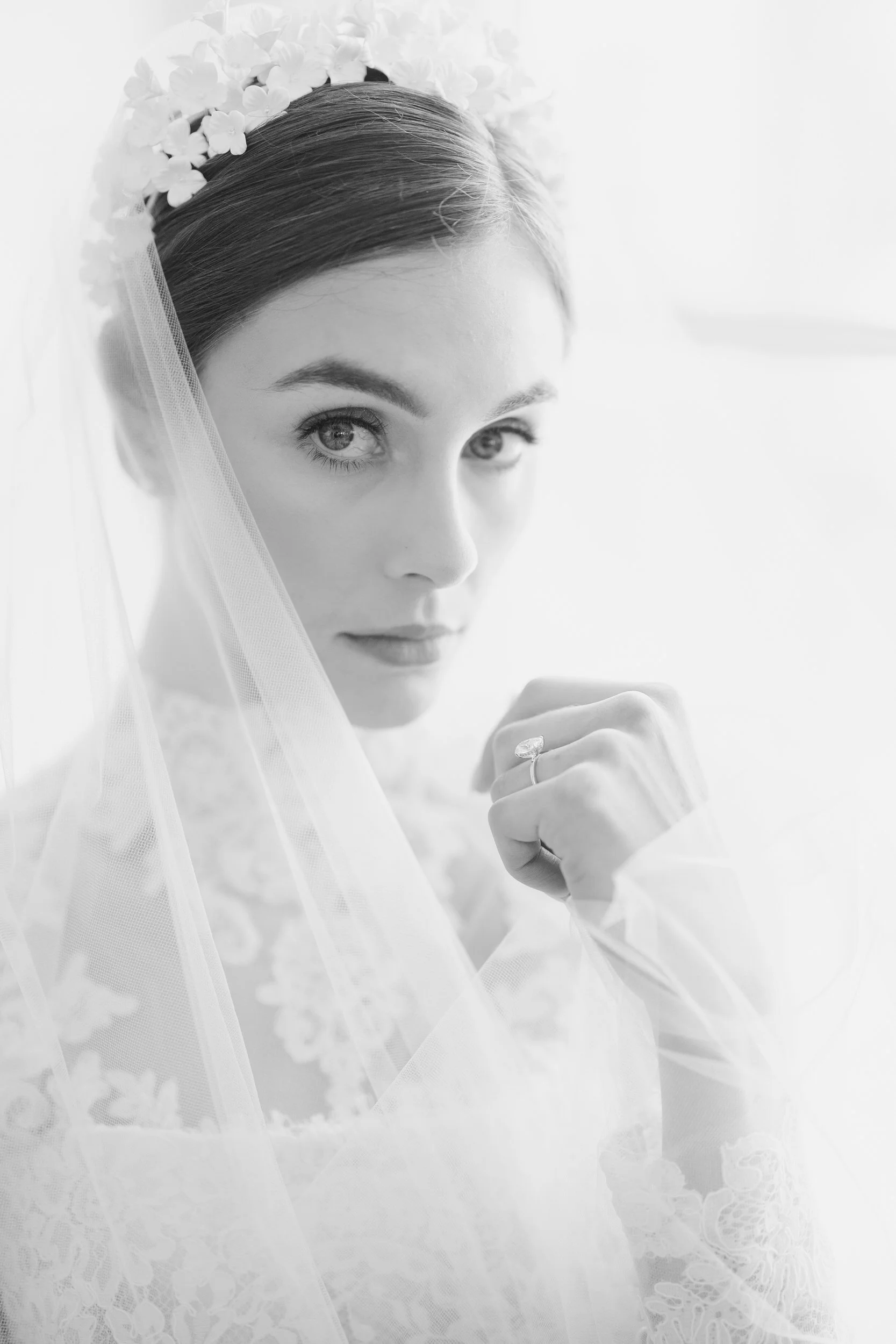 Elegant bridal portrait seated at Brasserie La Banque’s reception table in Charleston, South Carolina with soft neutral florals.