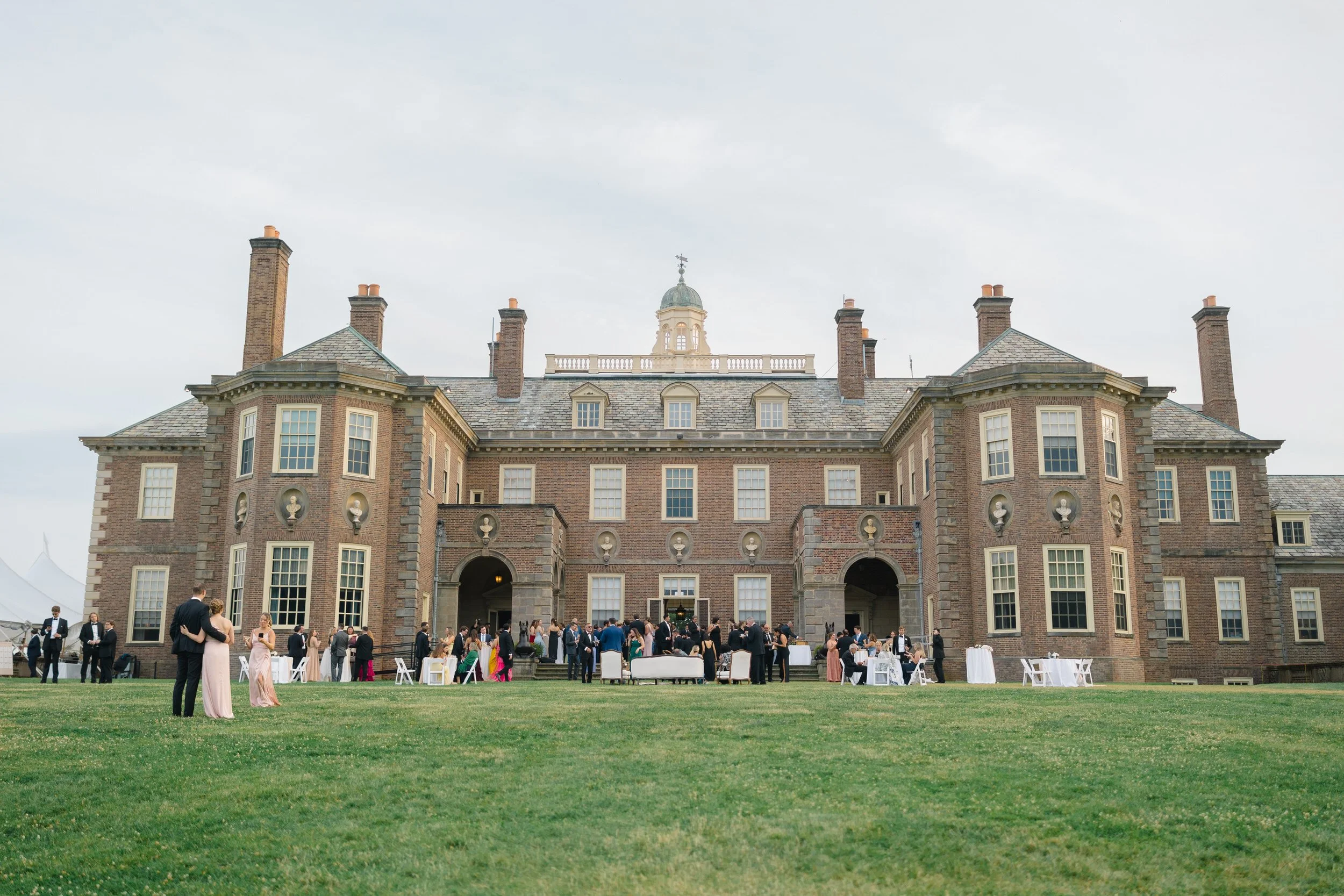 Guests mingling during outdoor cocktail hour on the Grand Allée at Castle Hill surrounded by the historic estate landscape.