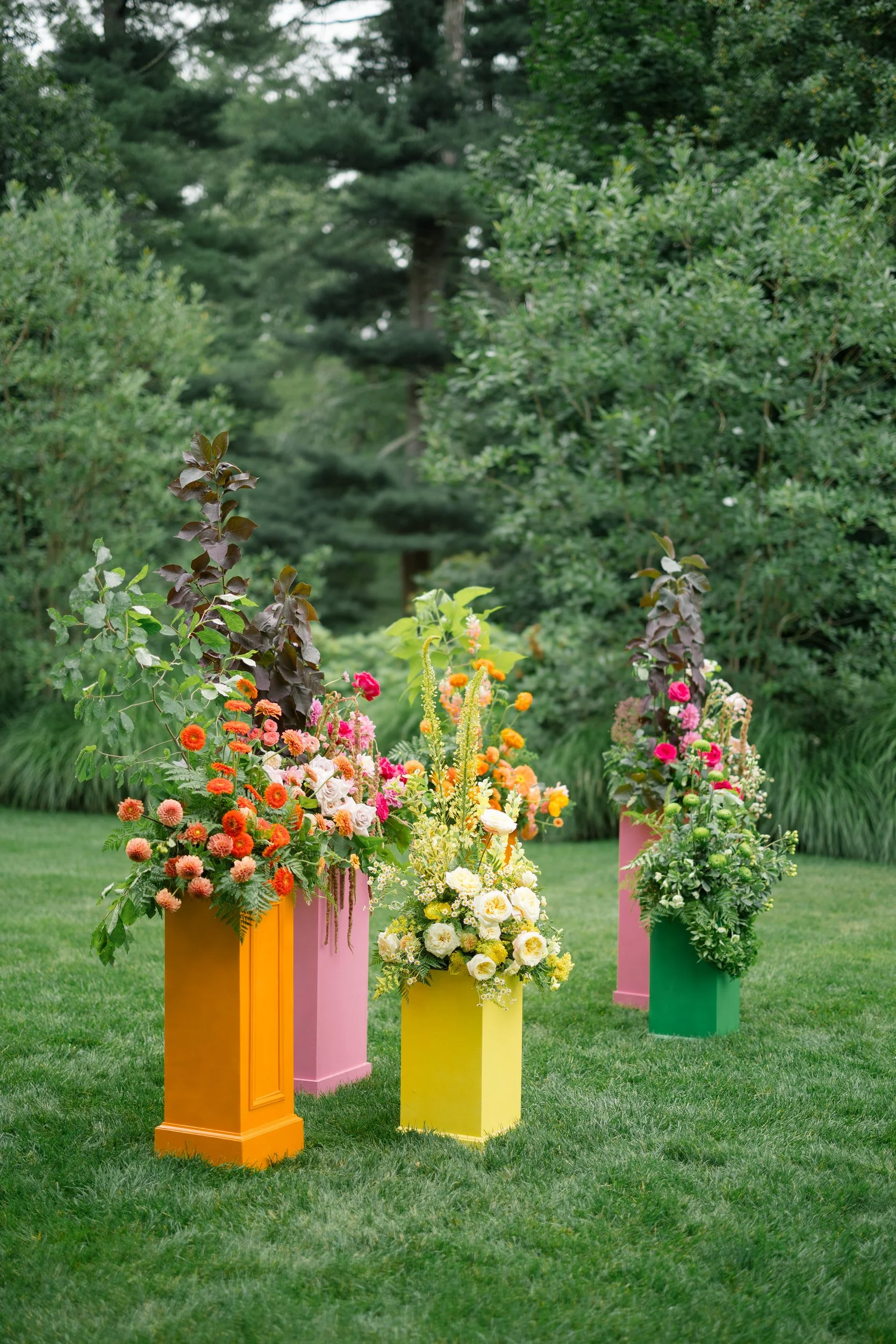 Garden ceremony installation overflowing with bright dahlias, English roses, and colorful poppies.