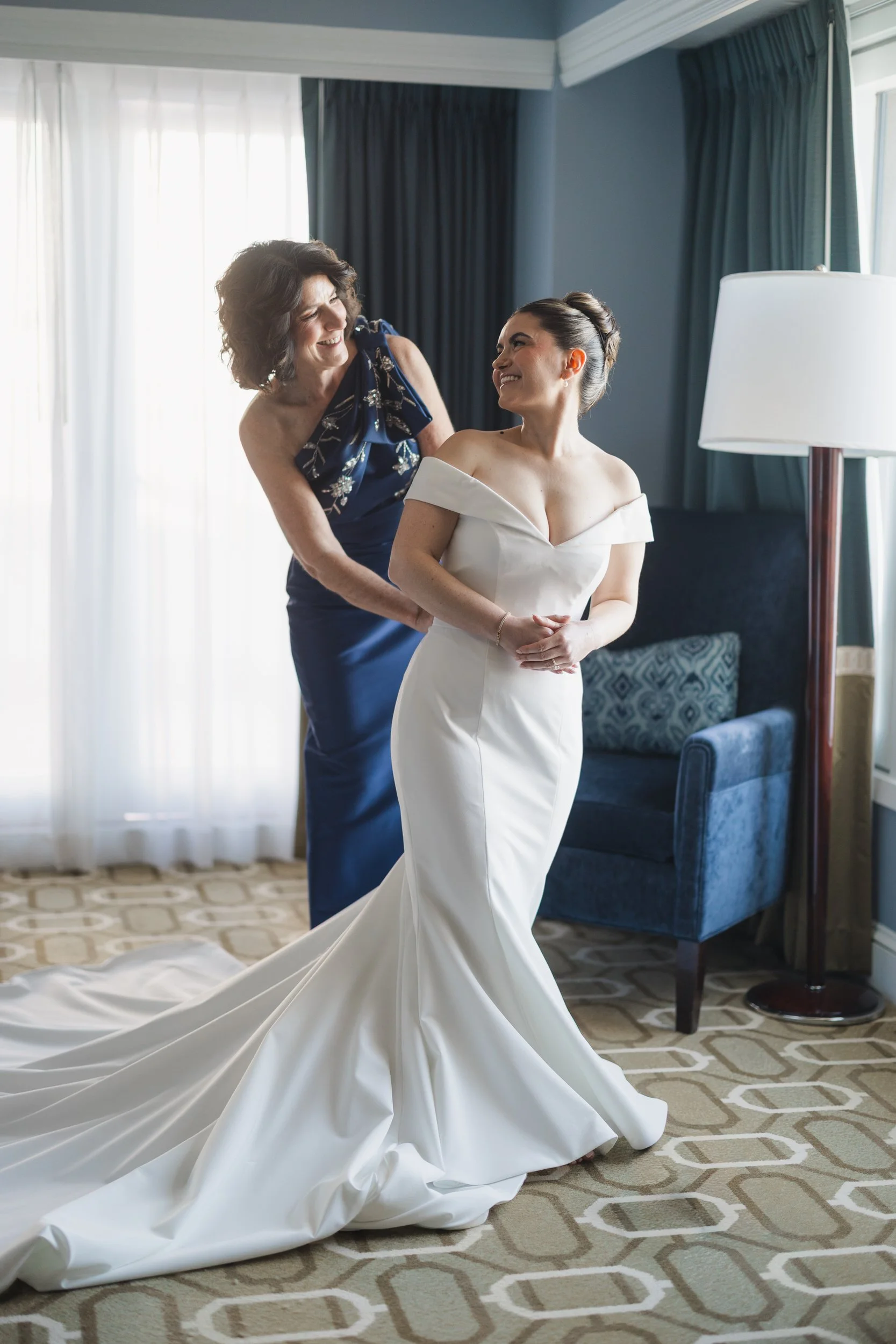 Bride stepping into her gown inside a Boston Harbor Hotel waterfront suite