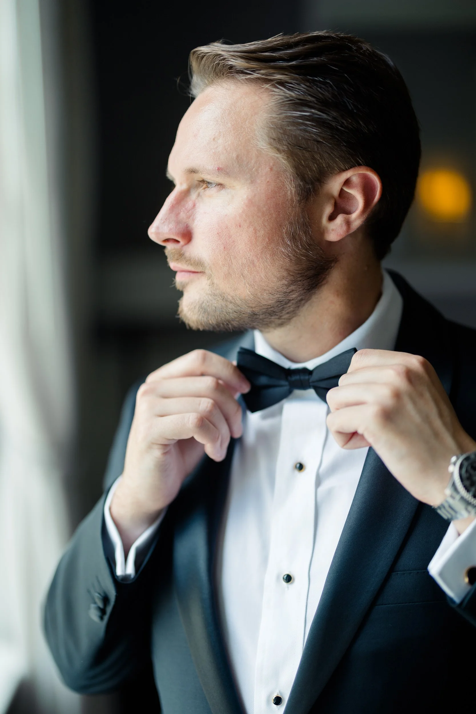 Groom adjusting tie before ceremony in Newport, RI