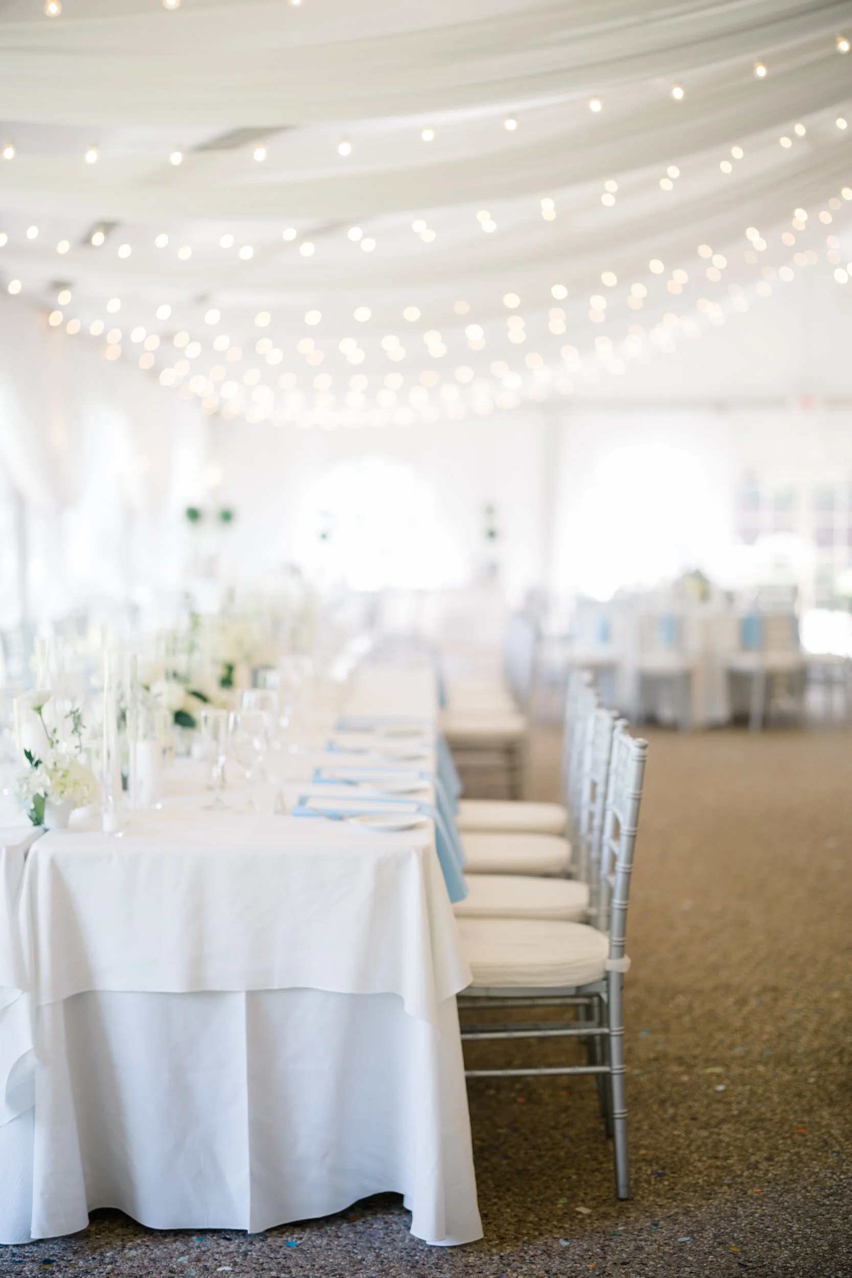 Elegant reception tables adorned with white and pastel blue floral arrangements.