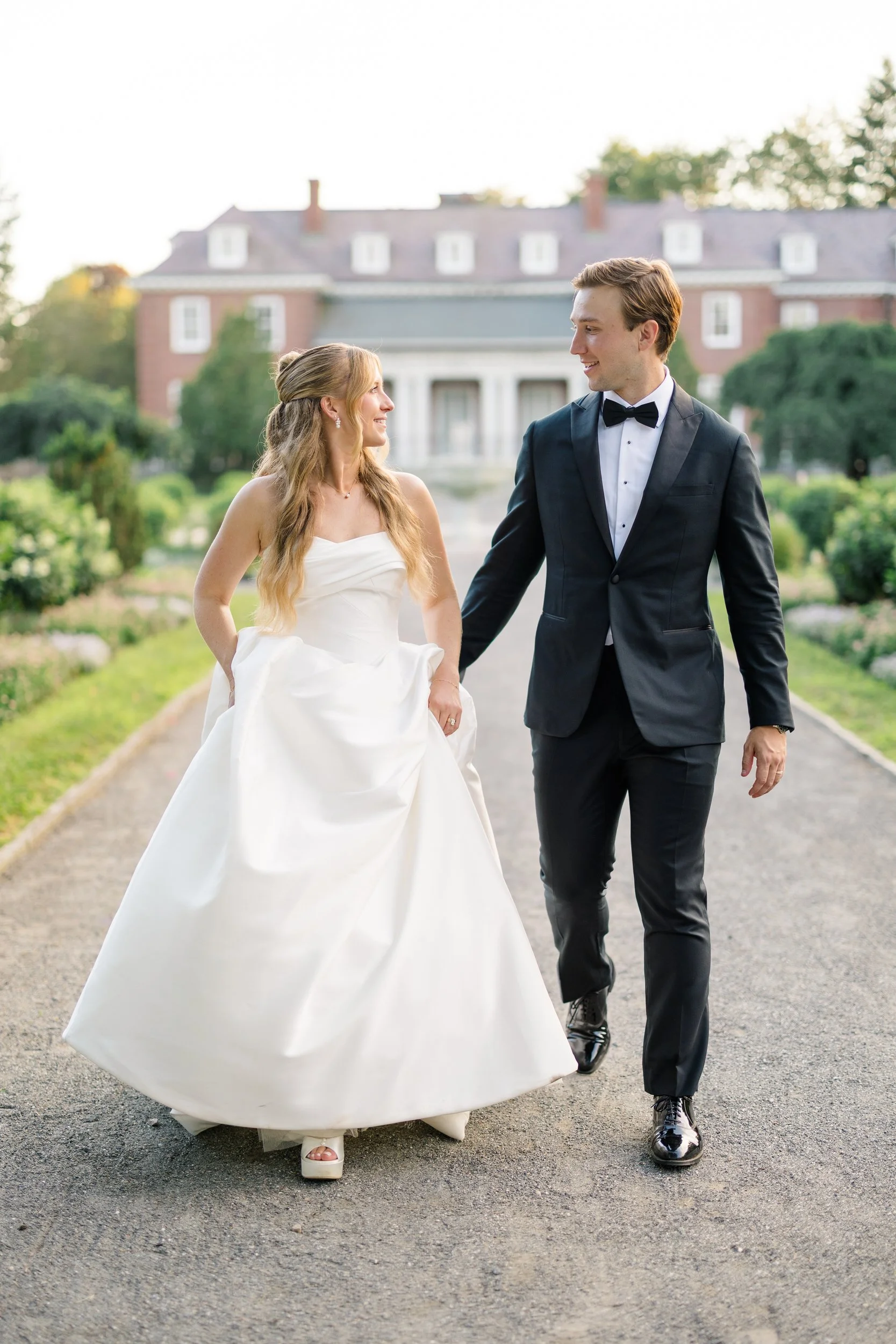 Bride and groom walking through the gardens at golden hour