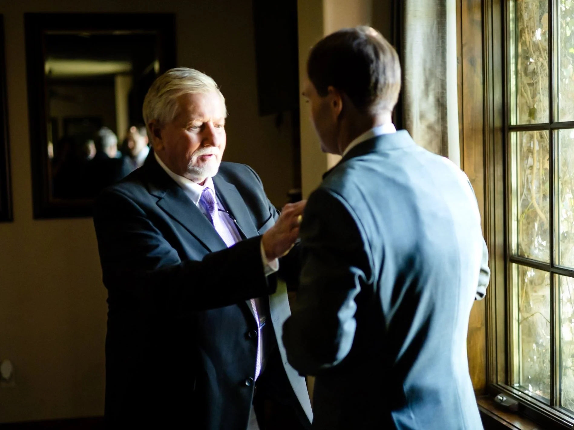 A father aligning his sons tie on his wedding day before the ceremony in Dallas, Texas