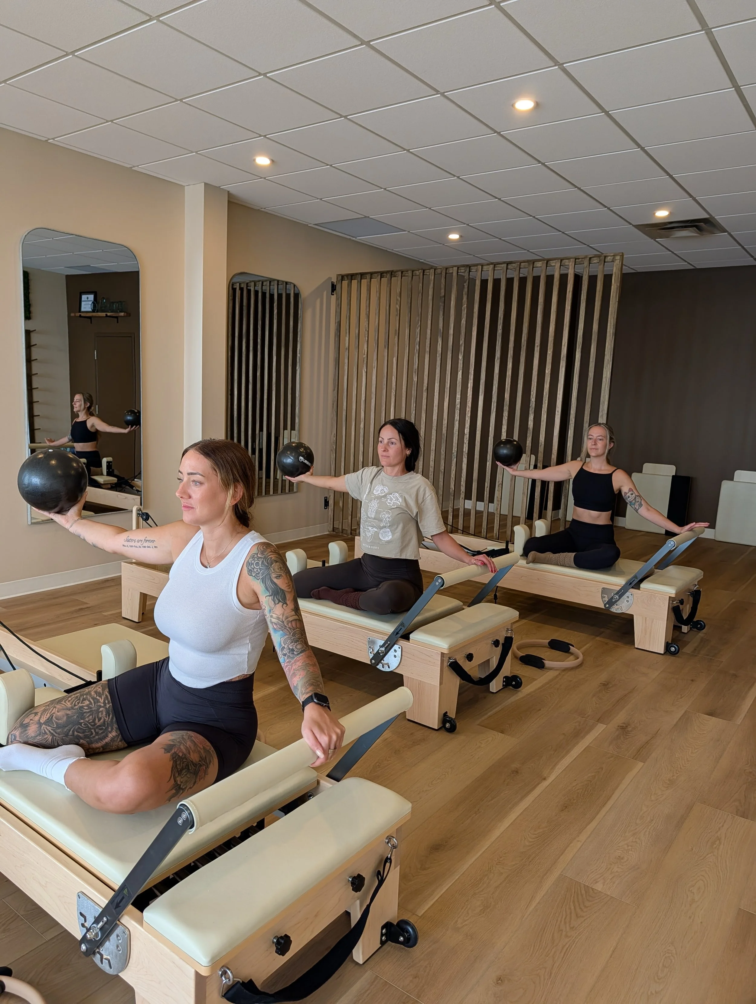 Group reformer class with individuals in mermaid using the ball