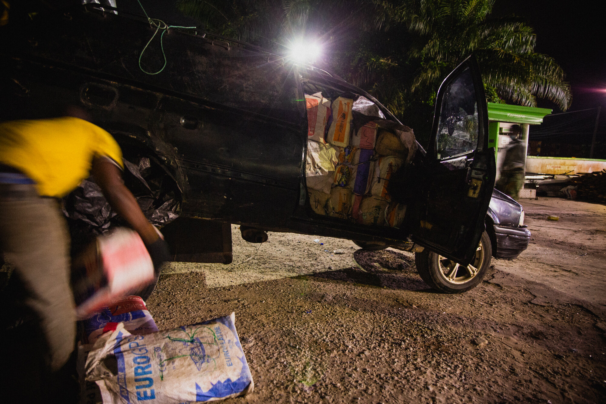  A man removing excess load from the ground after the car is fully loaded 