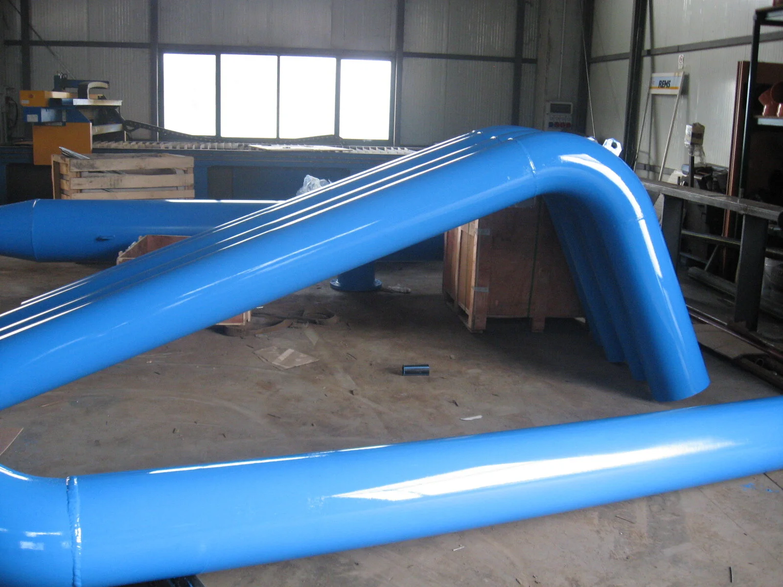 Una struttura in plastica blu gonfiabile, probabilmente una pista o un attrazione gonfiabile, collocata in un'officina o magazzino.