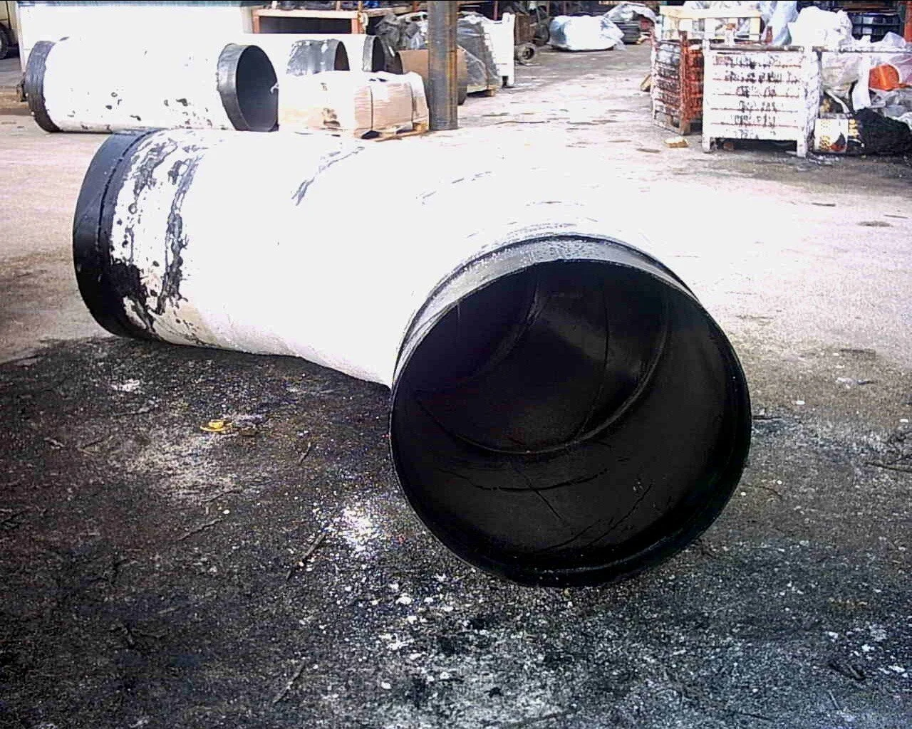 Serbatoi di grandi dimensioni e tubi in metallo riciclati in un magazzino o area di stoccaggio