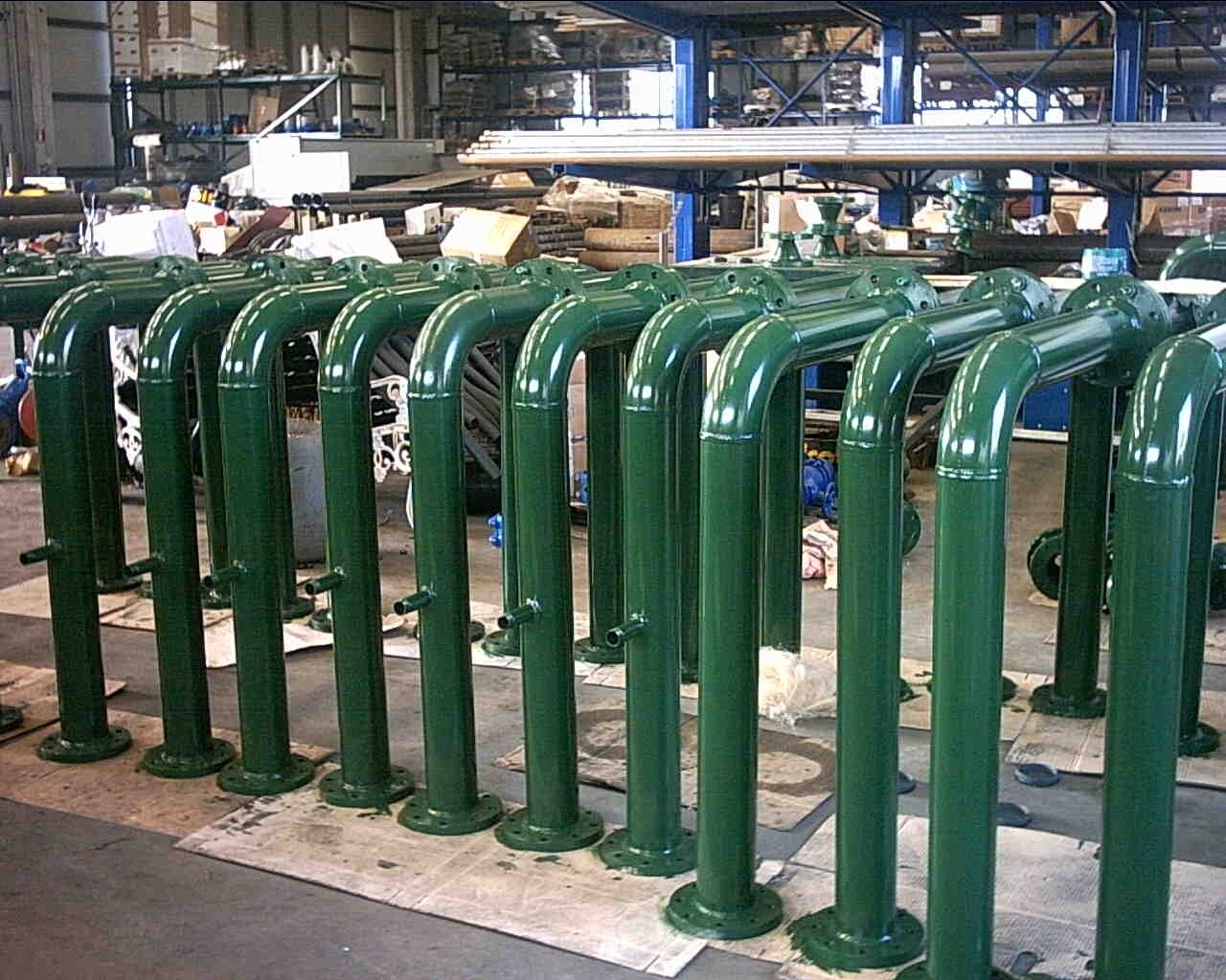 Serie di tubi verdi metallici in un'officina o magazzino industriale.