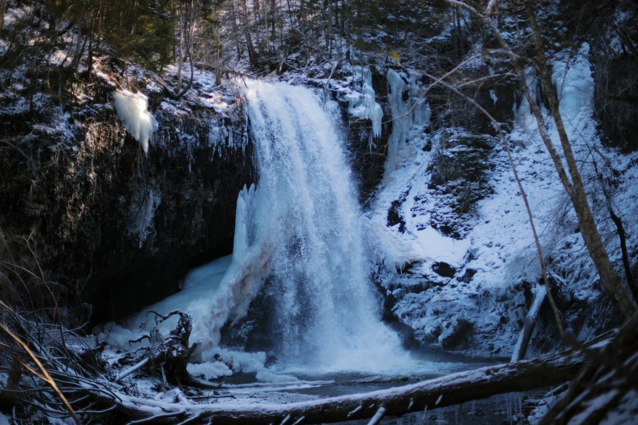 INSISTENT SHADOW &mdash;&mdash; The steady spray of late winter waterfalls is always waiting on the edge of freeze and thaw. It'll never be an monolith again, but each night brings a chance of an icy halo in this hollow. Everything in this zone expos