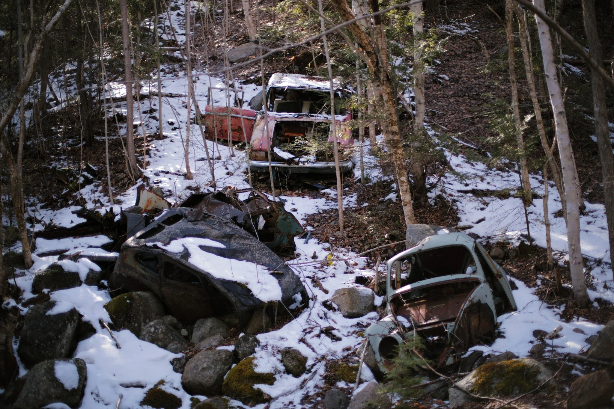 STRIPPED FOR PARTS &mdash;&mdash; Historic junkyards are scattered randomly all over my homeland. Often just a half-dozen vehicles like this, rolled down an embankment to rust in peace. These days, when your car dies, you'll more likely call up a loc