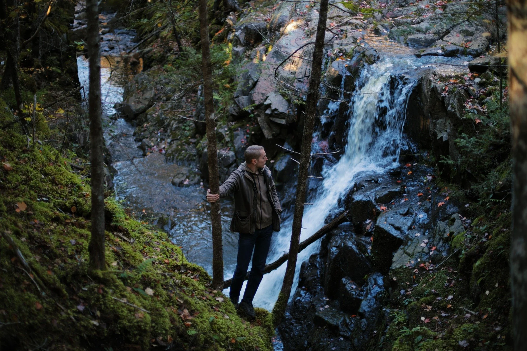 LIGHT LEADS &mdash;&mdash; Water cascades where the bedrock breaks on Granville Line Brook. Wide expanse of the world made bare, falling off and fading into shadow. In the hollows, scattered leaves are the only hint of seasons changing. Leaves spark 