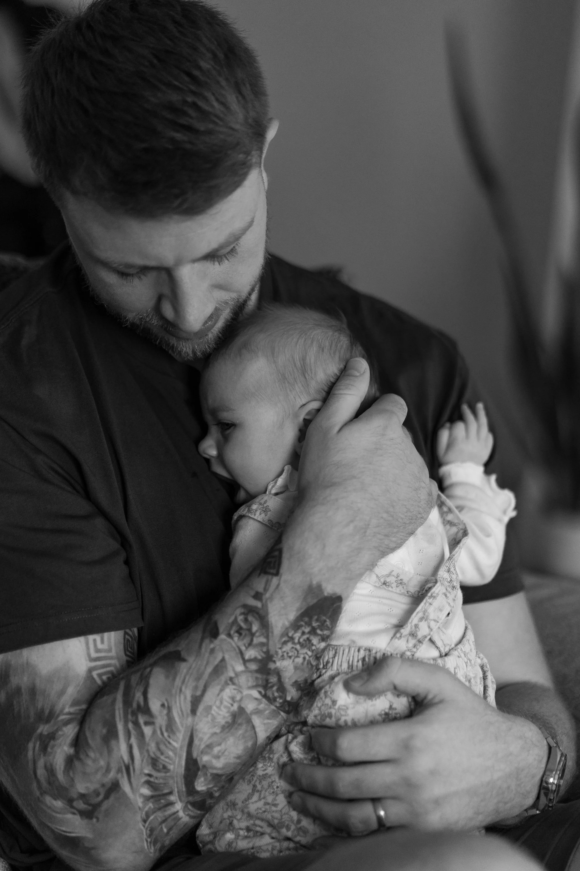 baby girl in tattoed dads arms 
