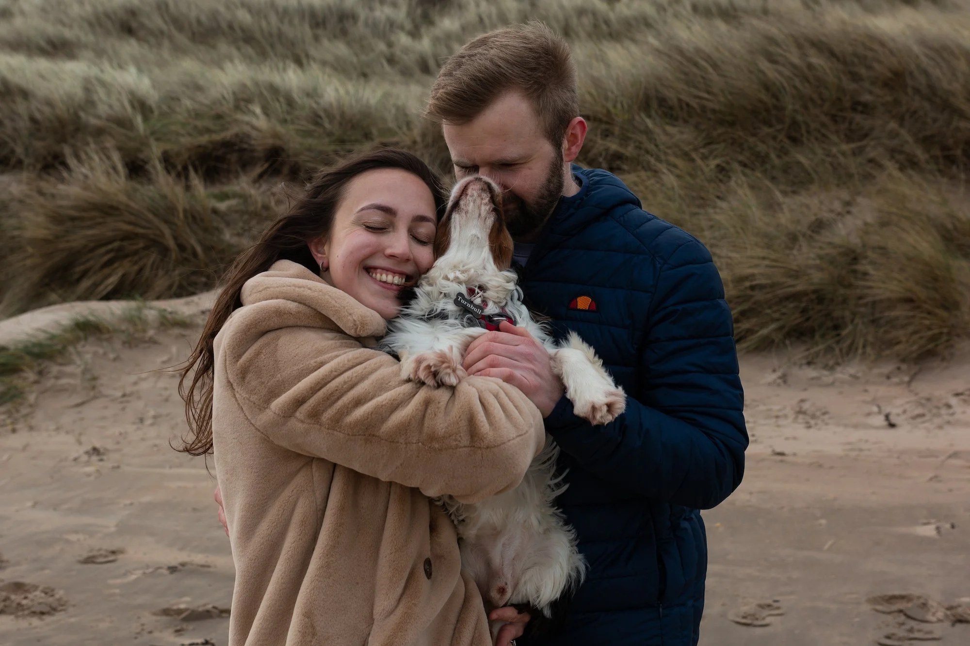 engagement photo shoot at the beach with their dog 