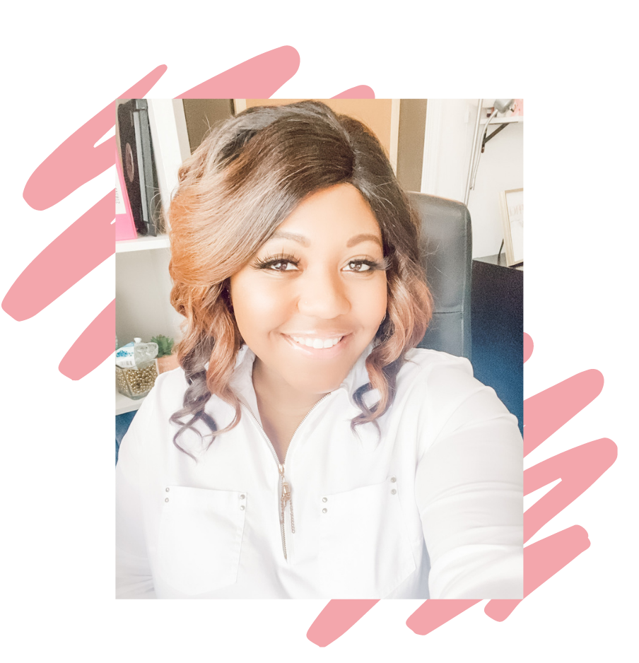 A smiling woman with shoulder-length wavy hair, wearing a white zipper top, sitting in an office chair with a bookshelf and framed picture in the background.